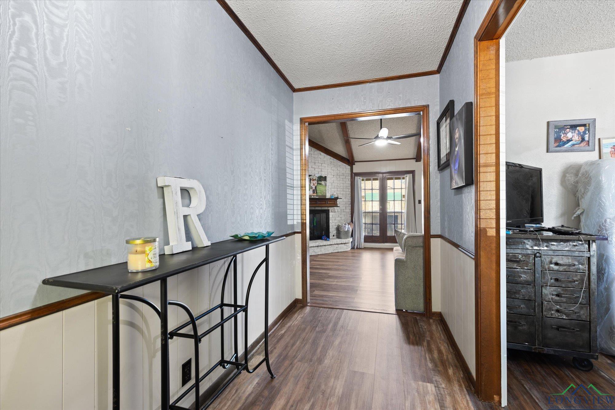 Image 3: Hallway featuring dark wood-style floors, crown molding, and a textured ceiling, Hallway