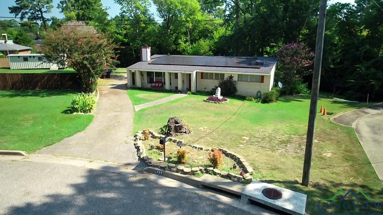 Image 0: Ranch-style house featuring solar panels, driveway, a front lawn, and a chimney, Front Of Structure