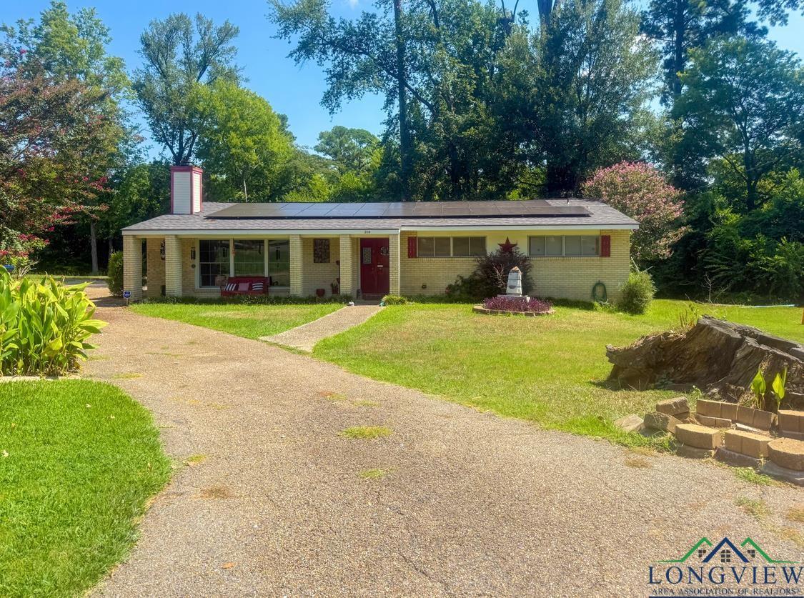 Image 2: Ranch-style home with brick siding, solar panels, and a front lawn, Front Of Structure