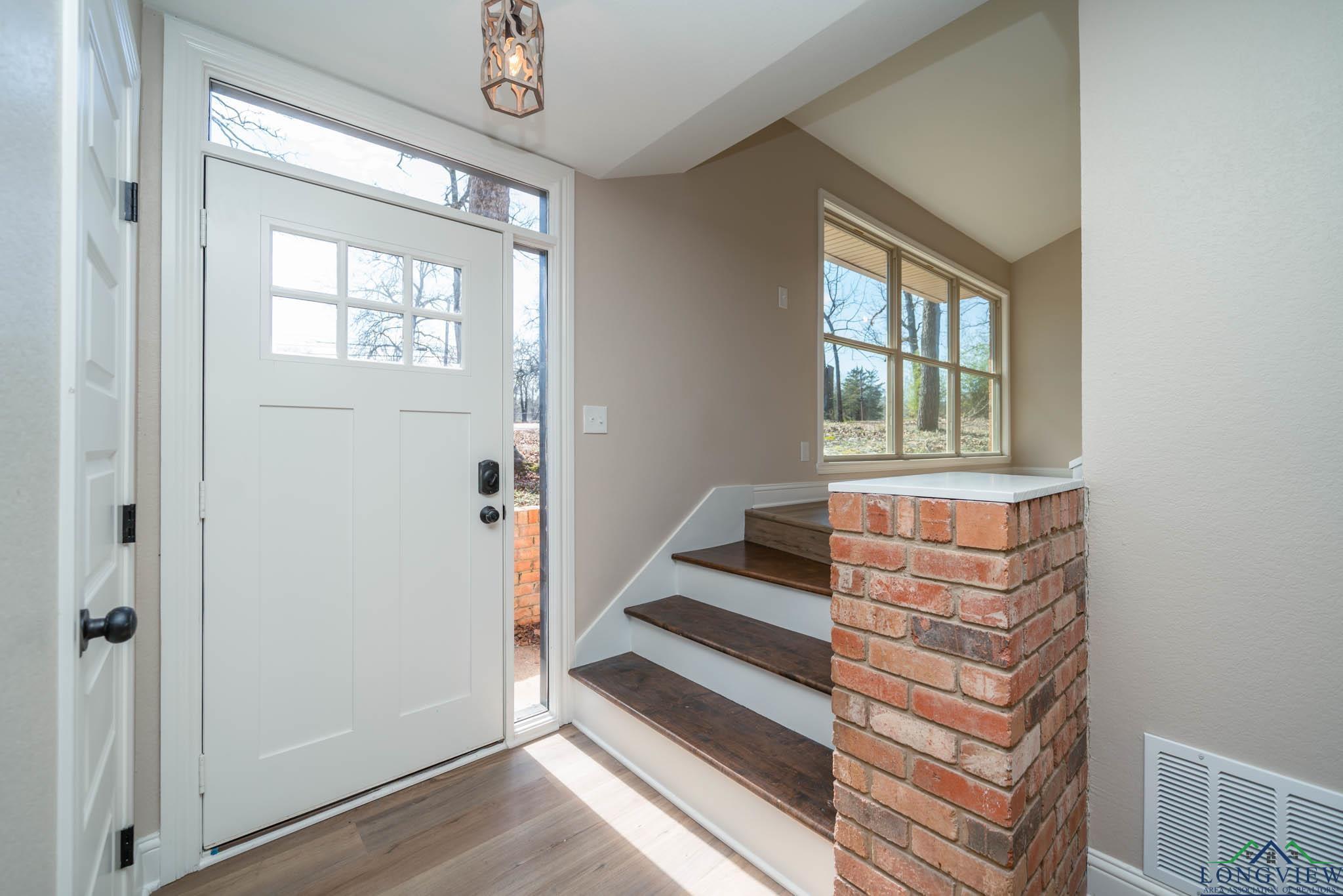 Image 2: Foyer featuring stairs, light wood finished floors, and lofted ceiling, Entrance Foyer