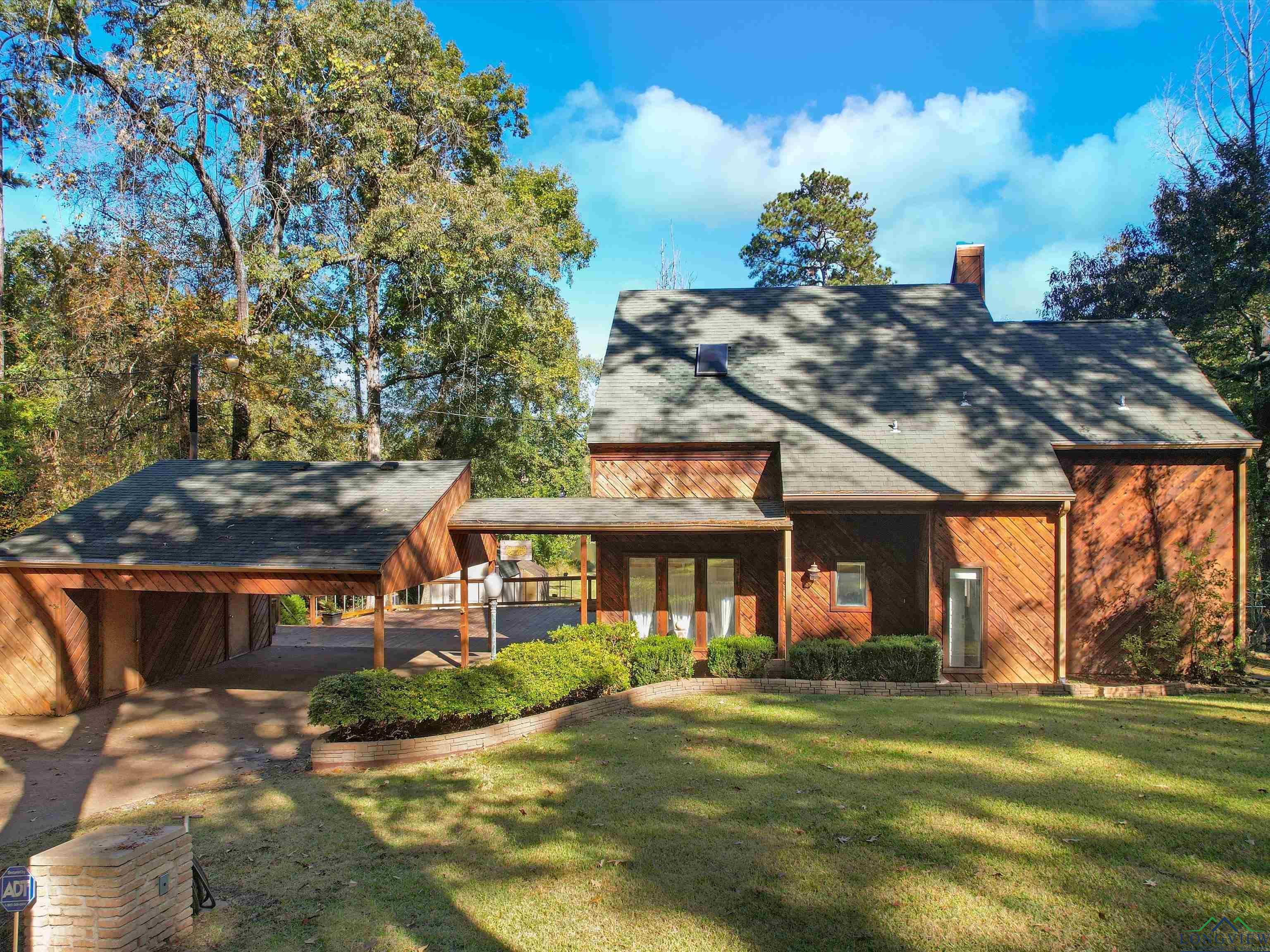 Image 0: View of front of property with a front yard, a chimney, a carport, and a shingled roof, Front Of Structure
