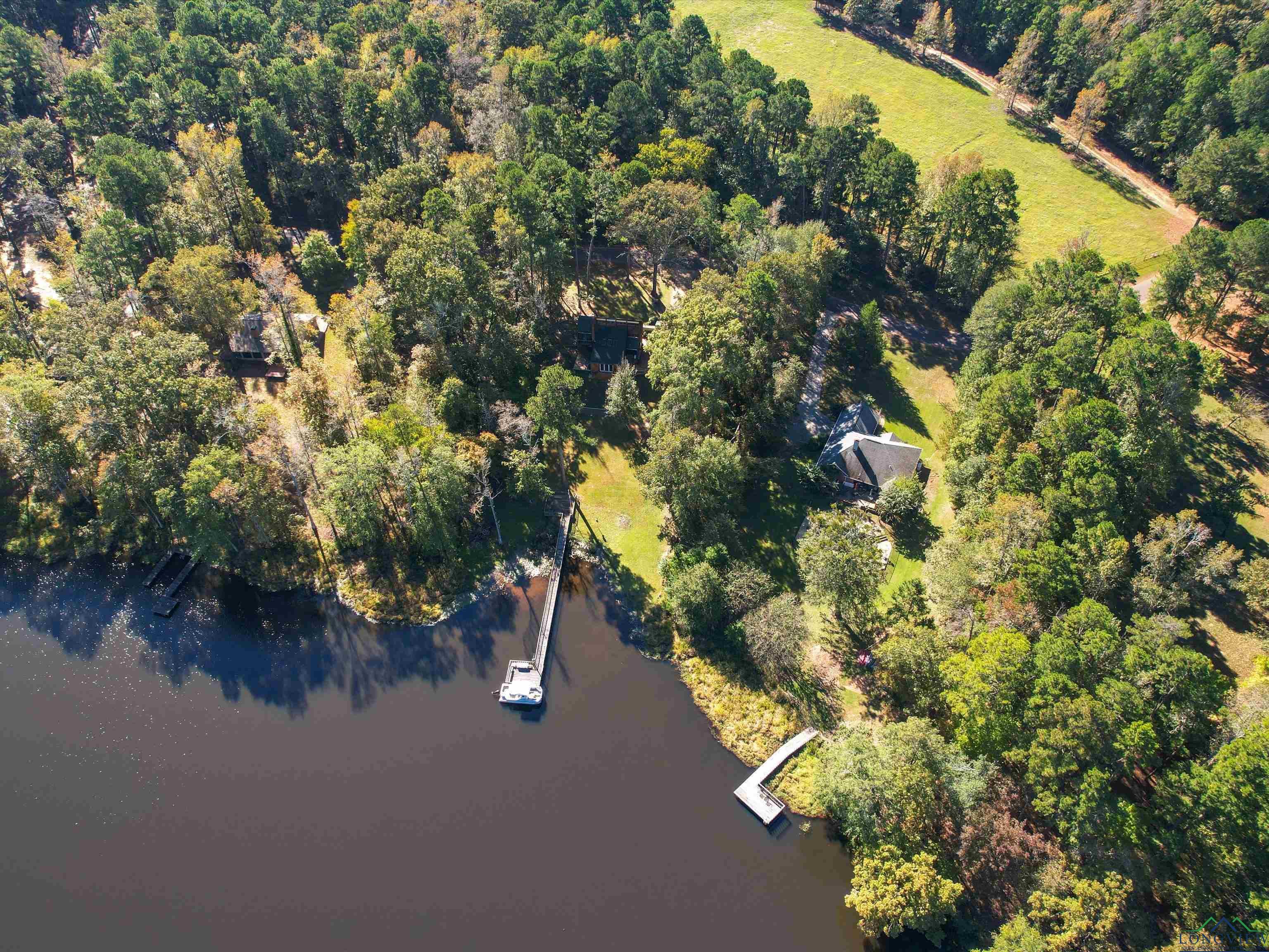 Image 2: View of property location with a large body of water and a heavily wooded area, Aerial View
