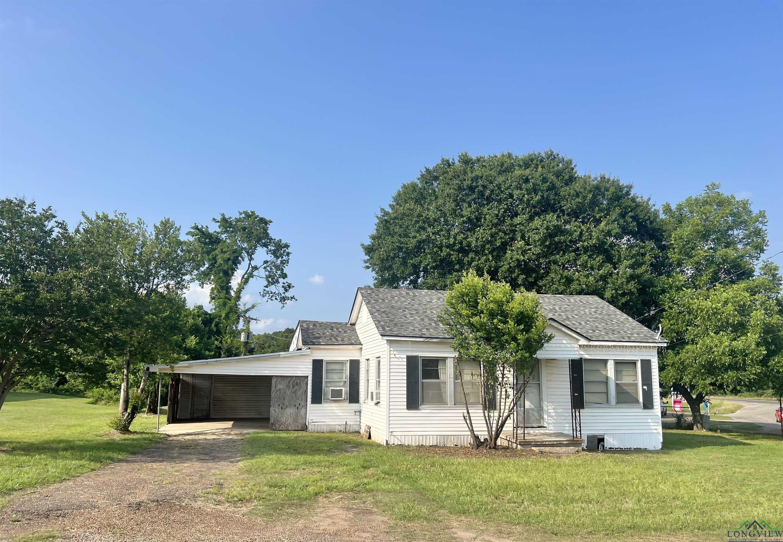 Image 0: View of front of home with driveway, a carport, a front lawn, and roof with shingles, Front Of Structure