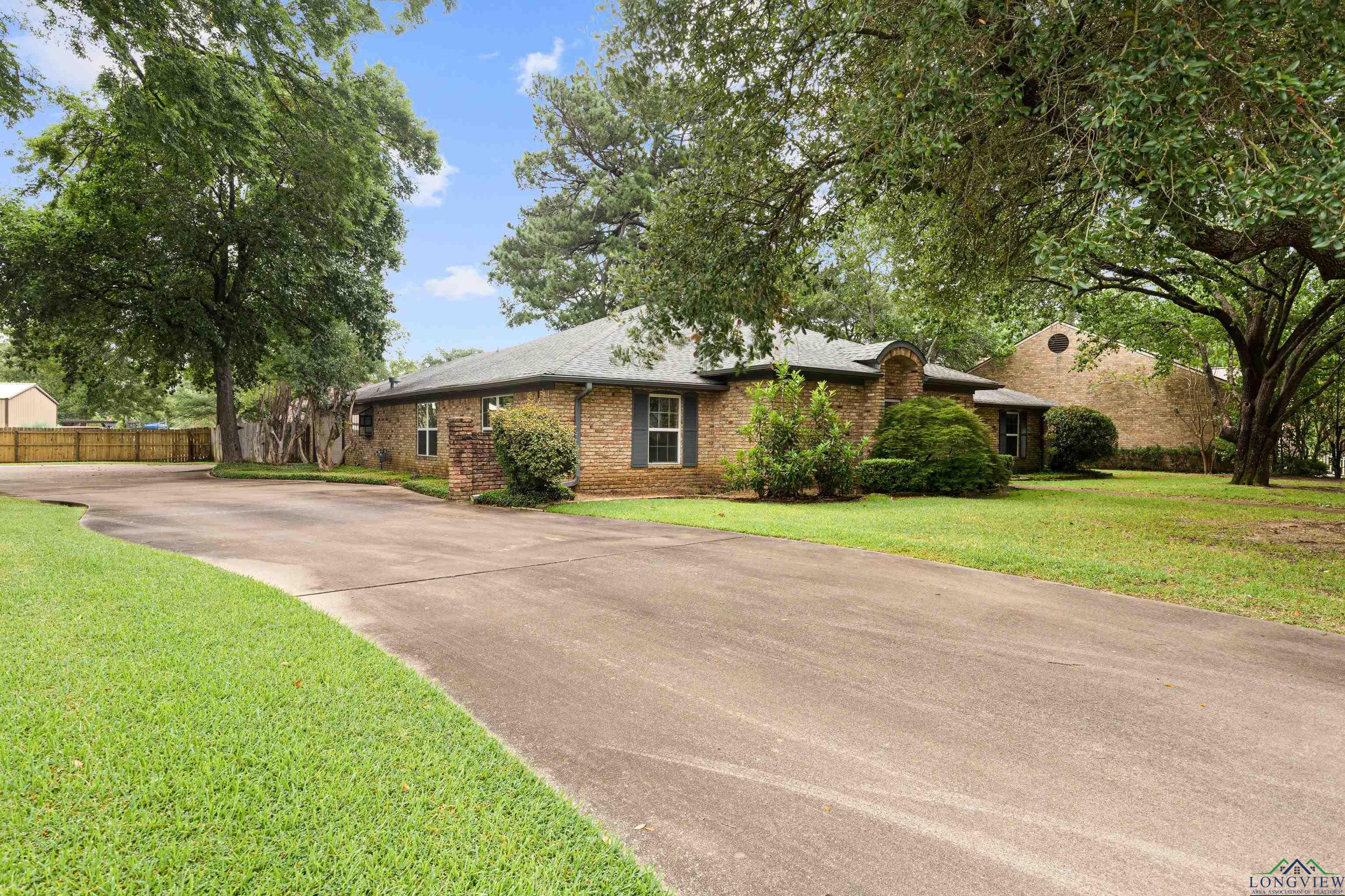 Image 1: Ranch-style home featuring concrete driveway and brick siding, Front Of Structure