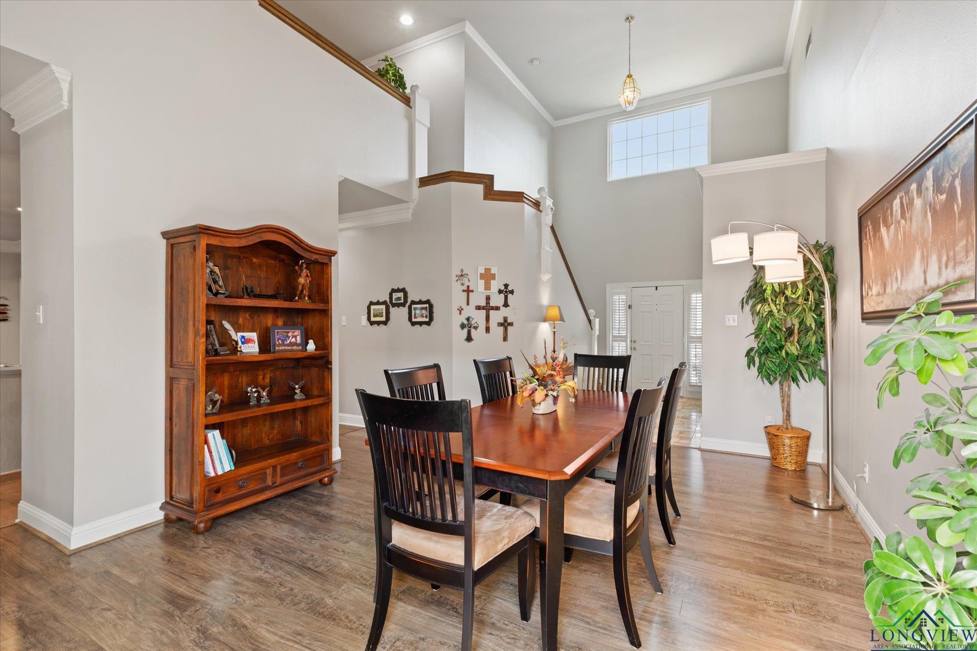 Image 3: Dining space featuring crown molding, a towering ceiling, and wood finished floors, Dining Area