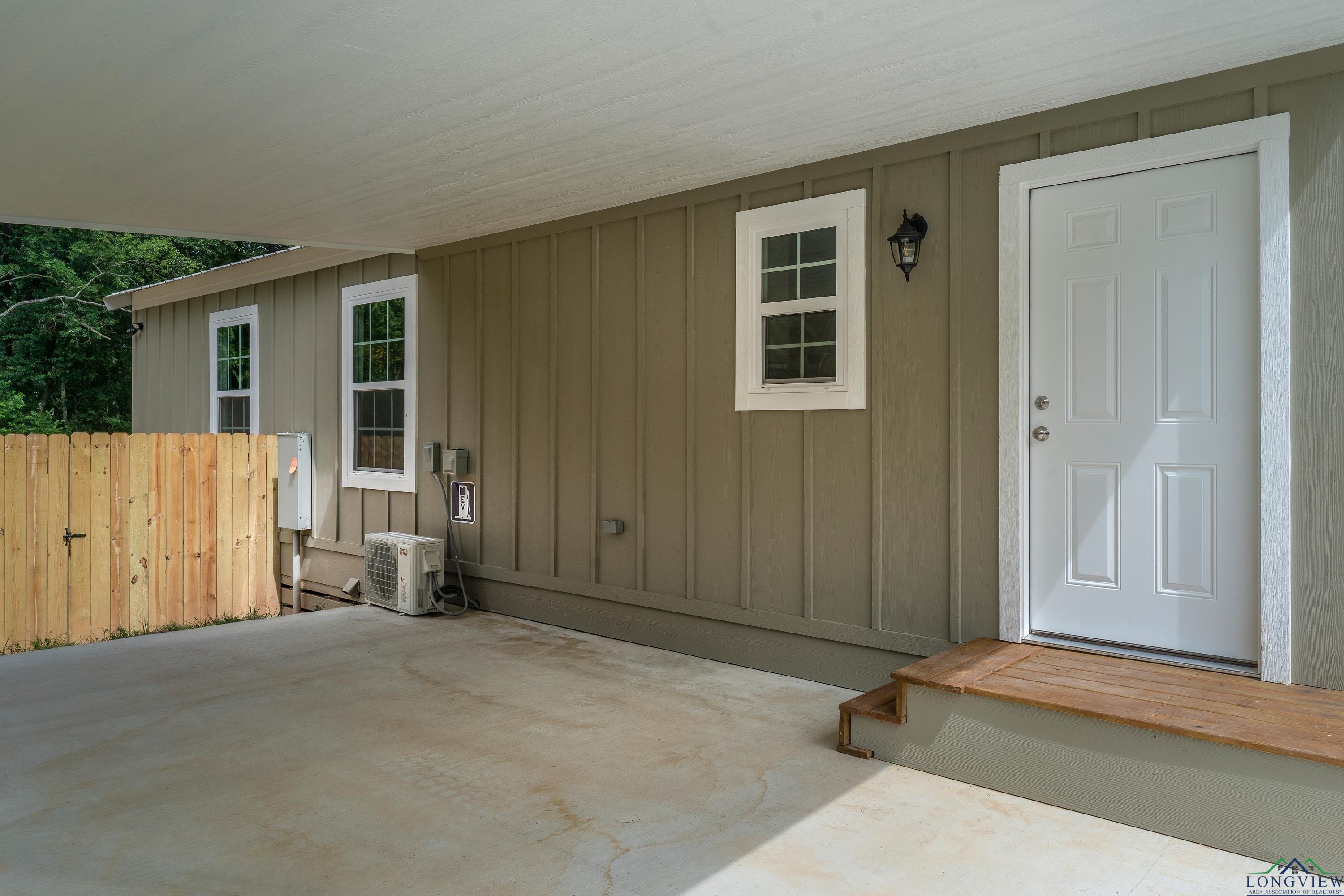 Image 2: Doorway to property with board and batten siding and a patio, Entry