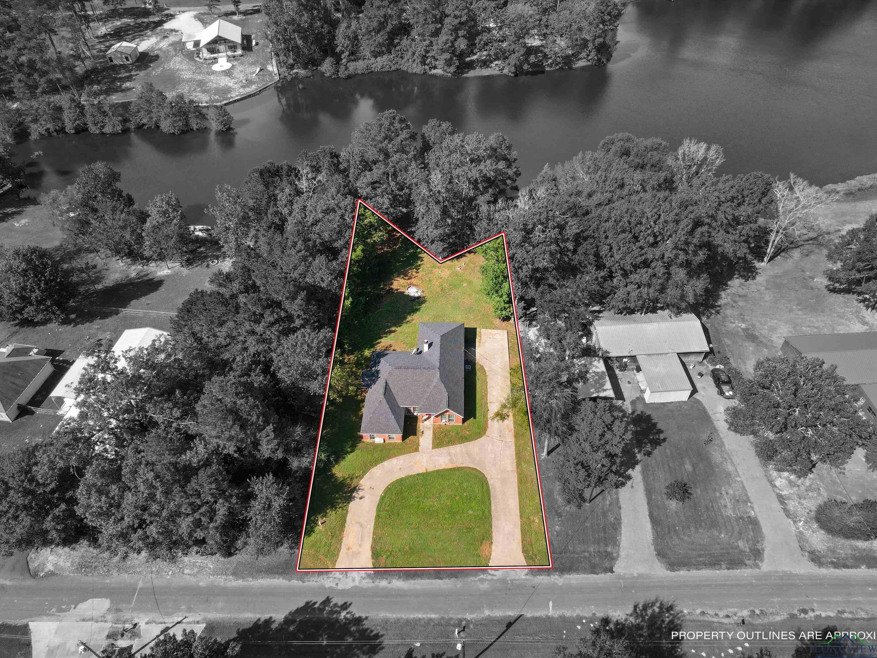 Image 1: Aerial view of property and surrounding area featuring property parcel outlined and a nearby body of water, Aerial View