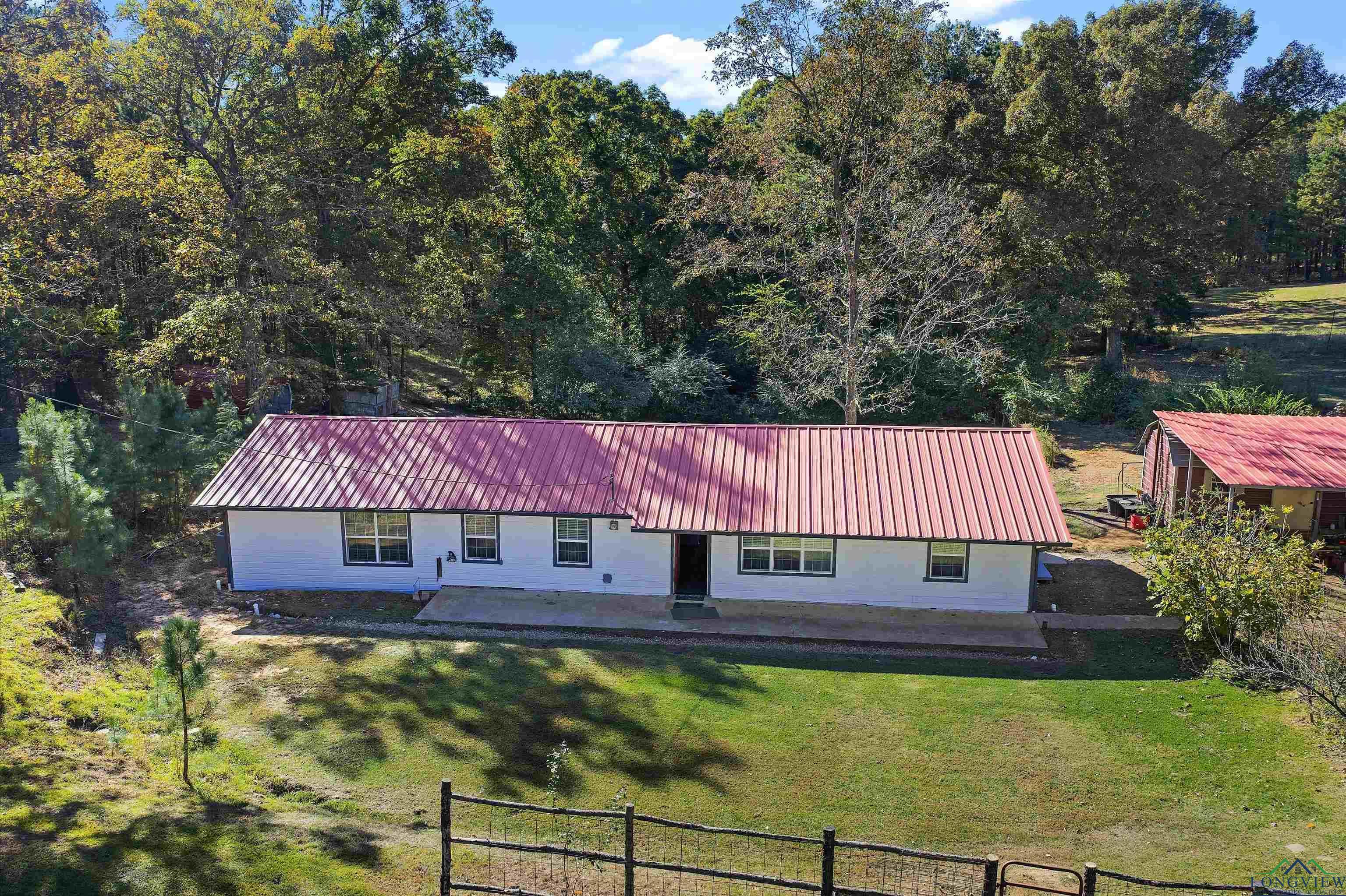 Image 0: View of front of house with a metal roof, a front yard, and a patio area, Front Of Structure