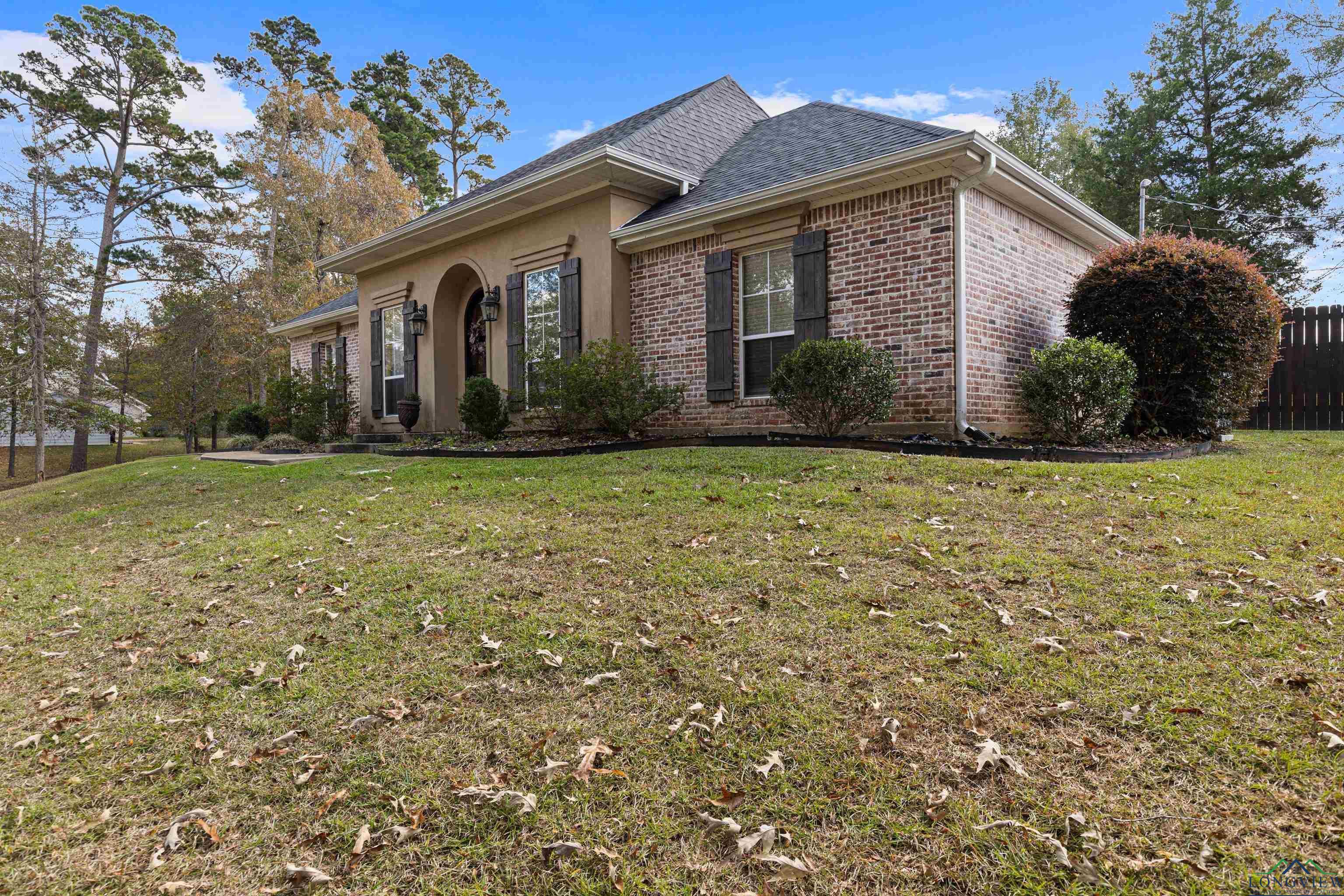 Image 2: View of front of property with brick siding, a shingled roof, and stucco siding, Front Of Structure