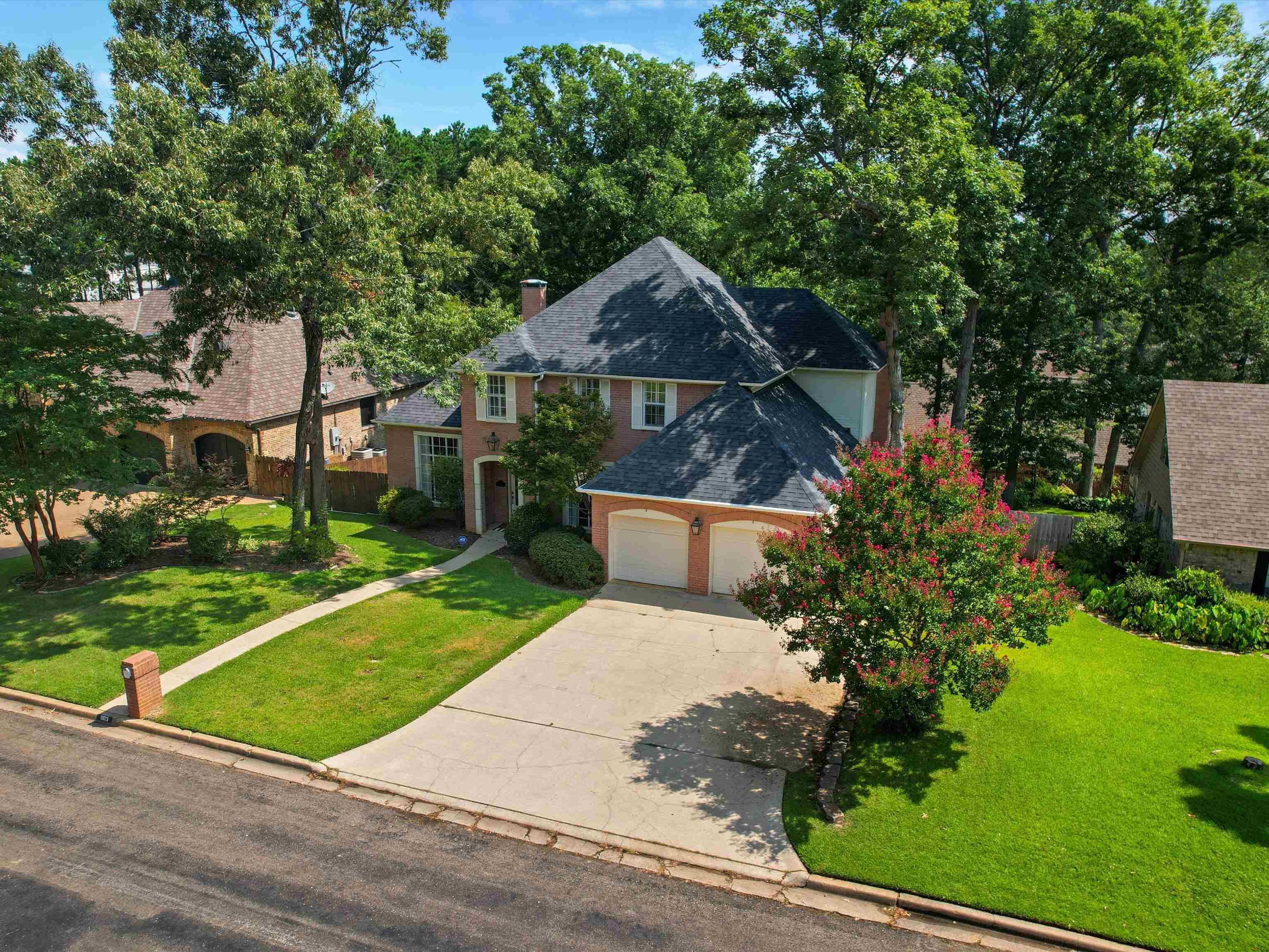 Image 1: Brick two-story residence with a dark shingle roof, Front Of Structure