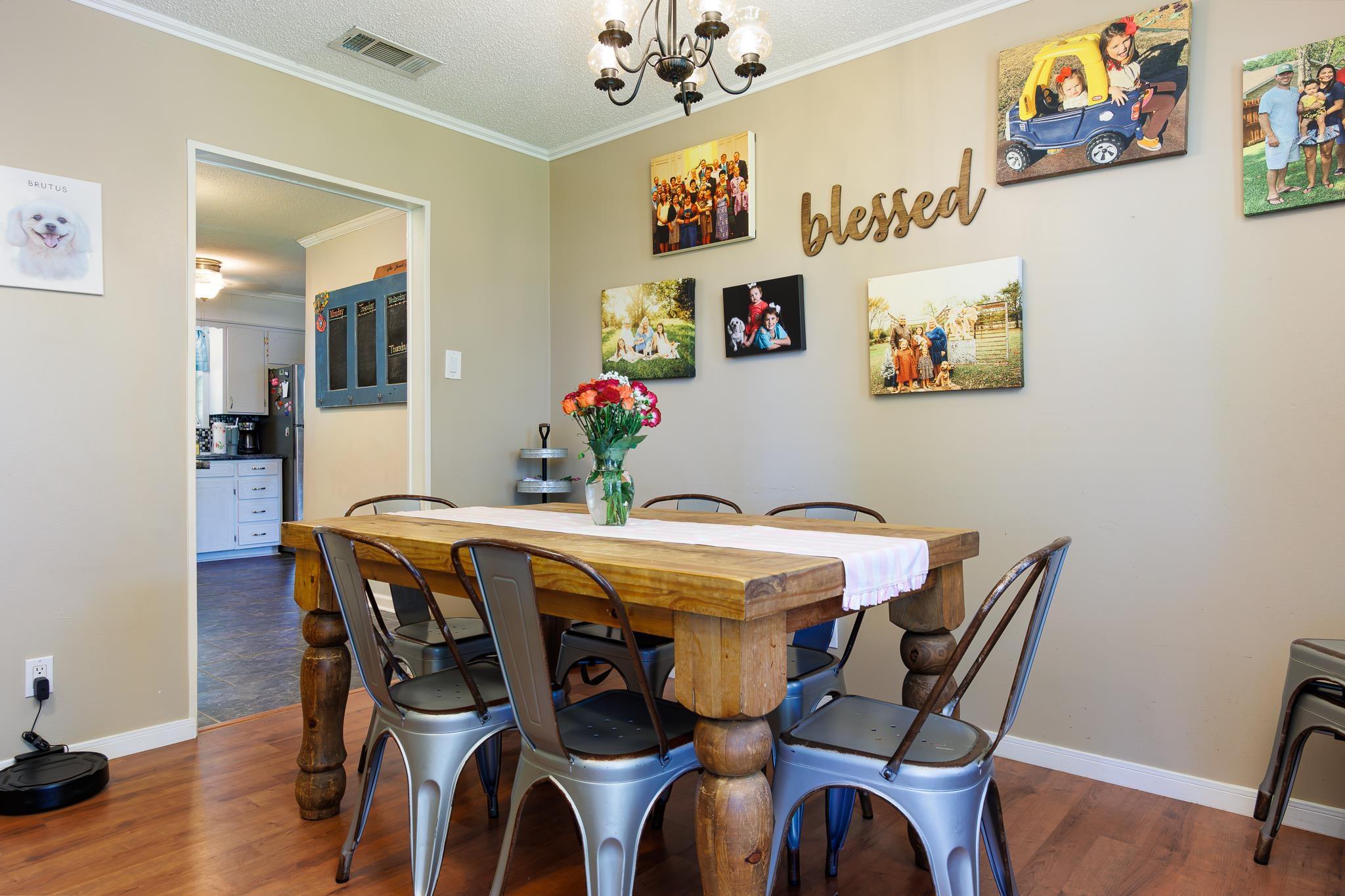 Image 2: Dining area with wood-finish flooring, a chandelier lighting fixture, and crown molding, Dining Area