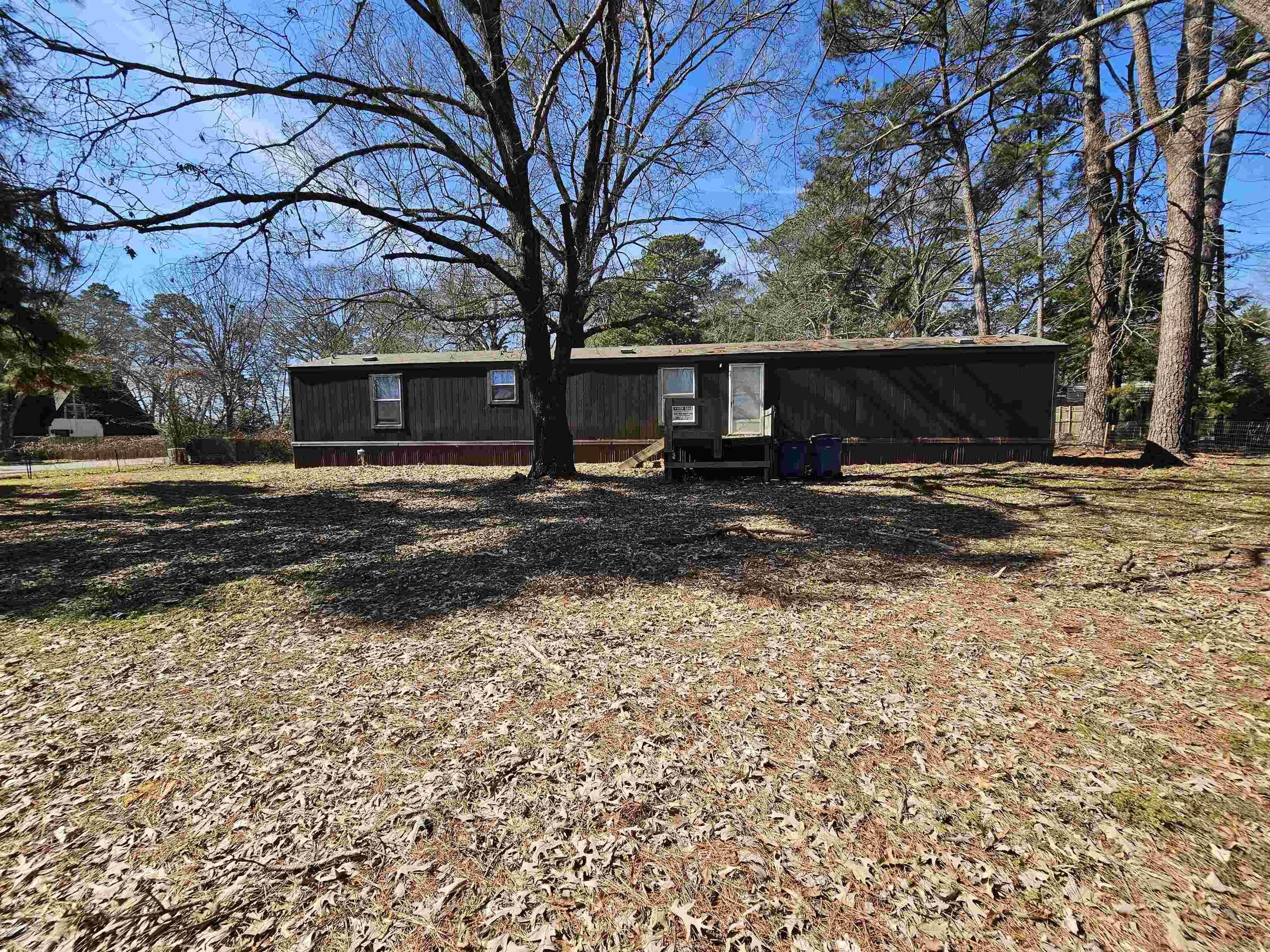 Image 0: Single-story structure with a dark exterior and lighter trim, Front Of Structure