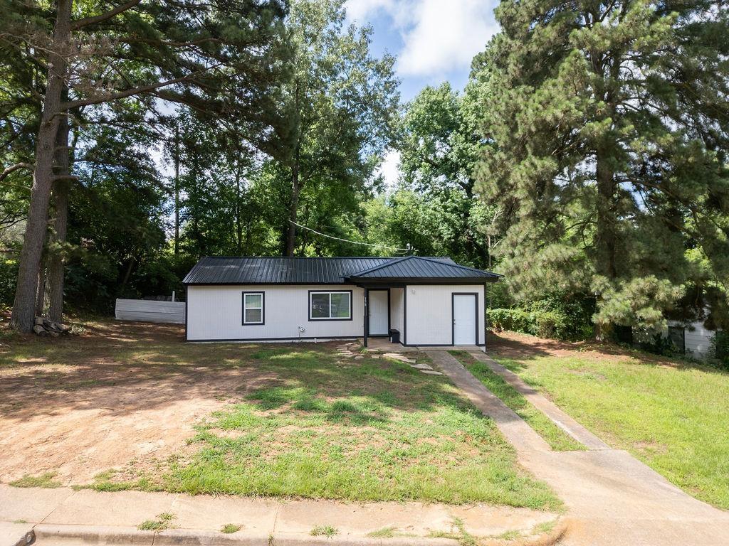 Image 0: Contemporary single-story residence featuring a black metal roof and white siding, Front Of Structure