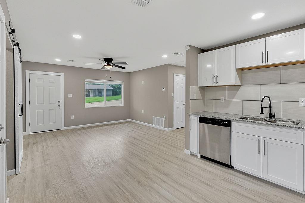 Image 2: Open concept living area featuring light wood-finish flooring, recessed lighting, and a ceiling fan, Kitchen