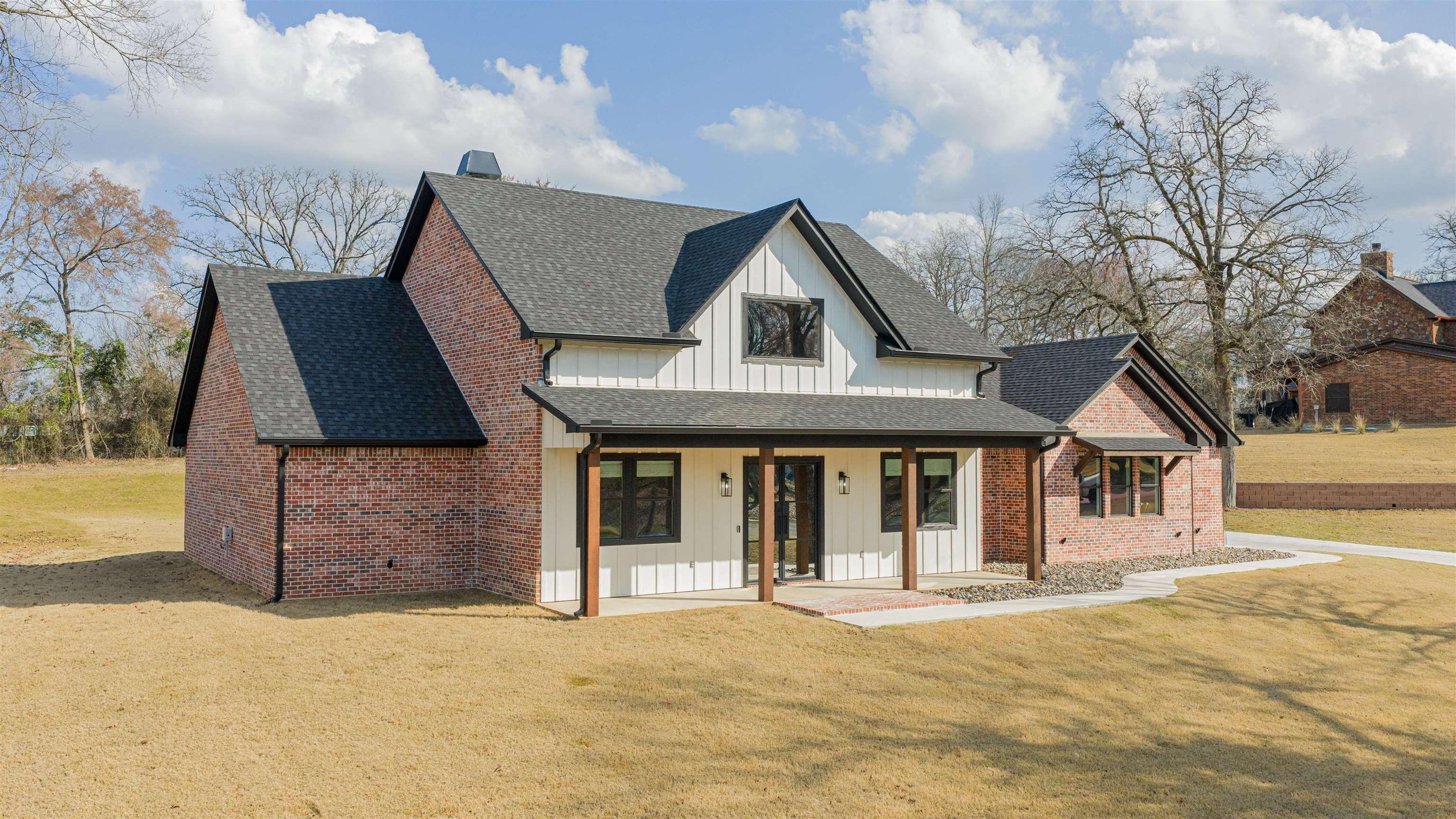 Image 0: Modern inspired farmhouse featuring board and batten siding, a porch, roof with shingles, and a front yard, Front Of Structure