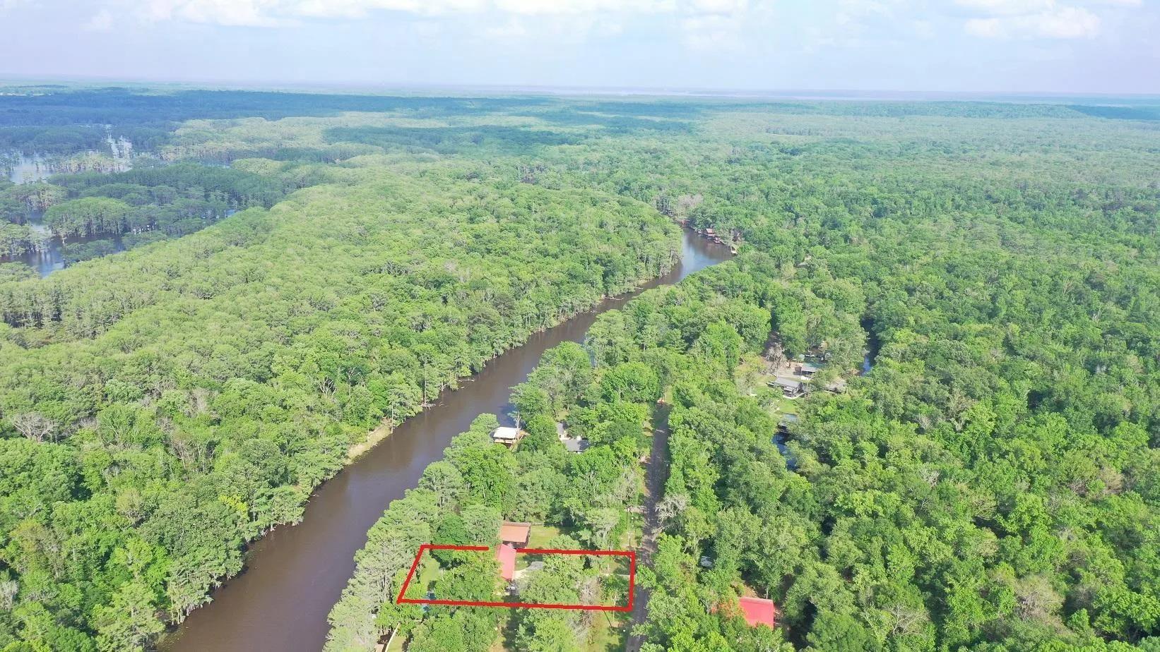 Image 1: Waterfront property set within a dense forest, featuring a prominent river, Aerial View