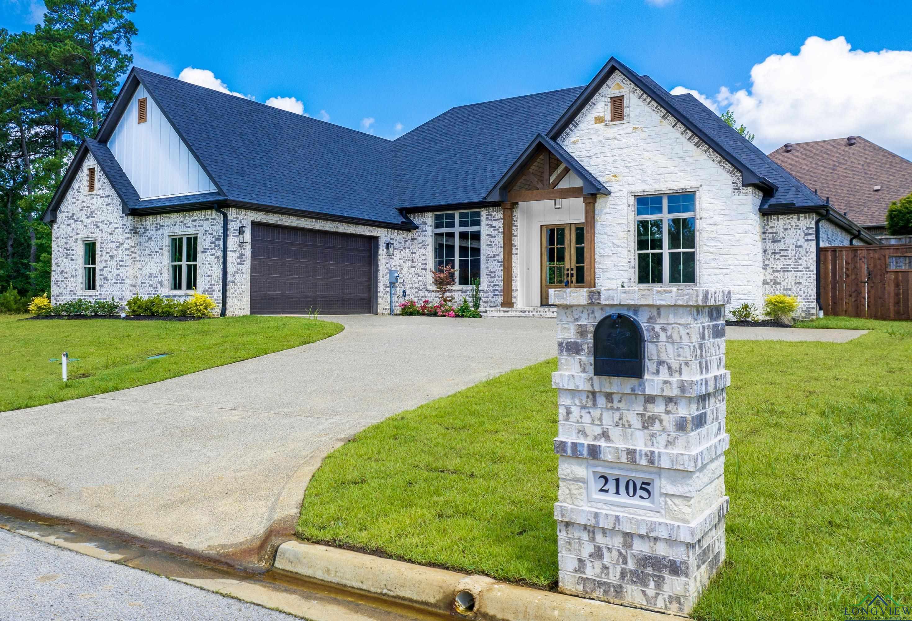 Image 1: French country home with stone siding, a garage, a shingled roof, concrete driveway, and board and batten siding, Front Of Structure