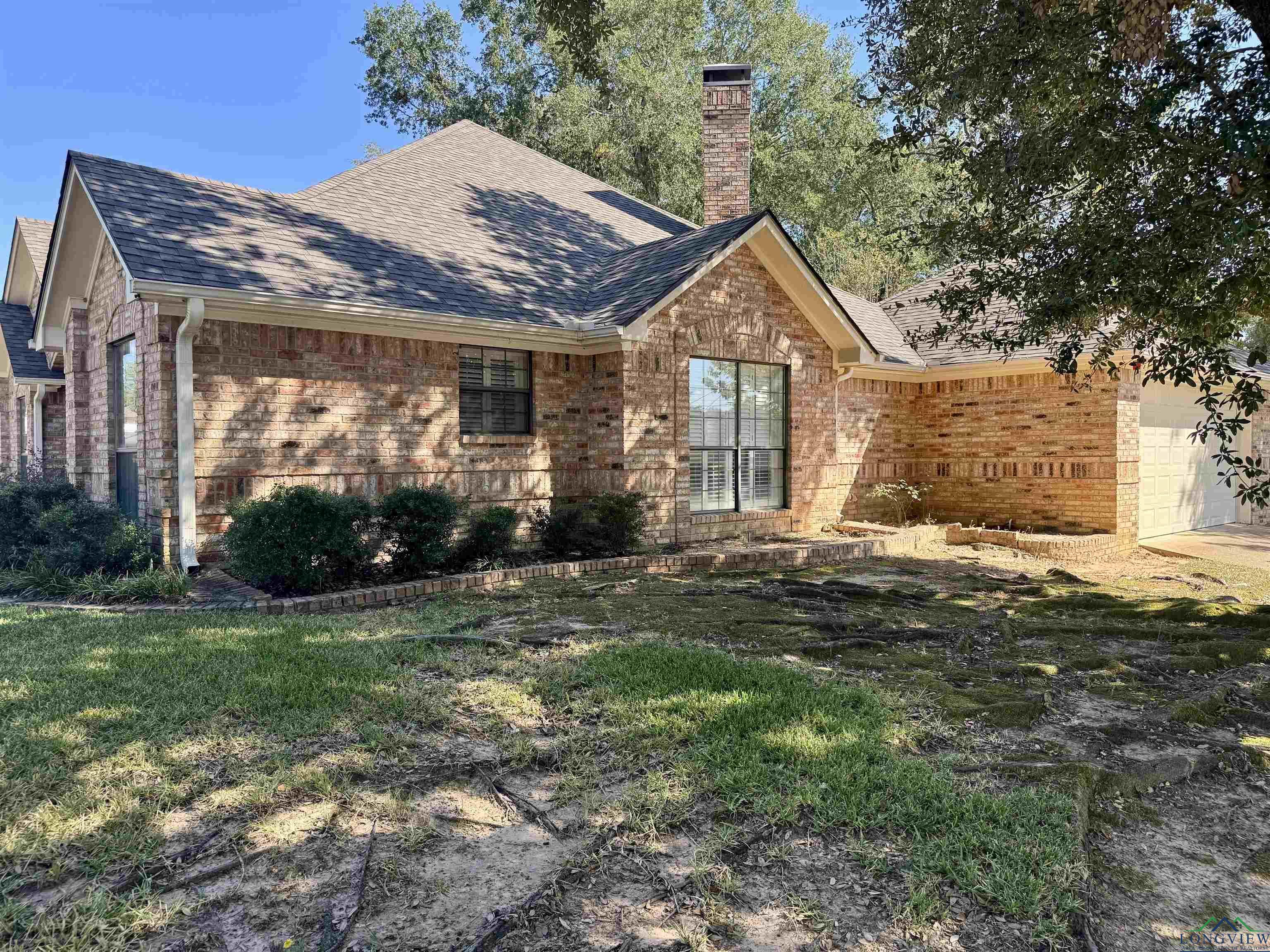 Image 1: Ranch-style home with a shingled roof, brick siding, an attached garage, a chimney, and a front yard, Front Of Structure