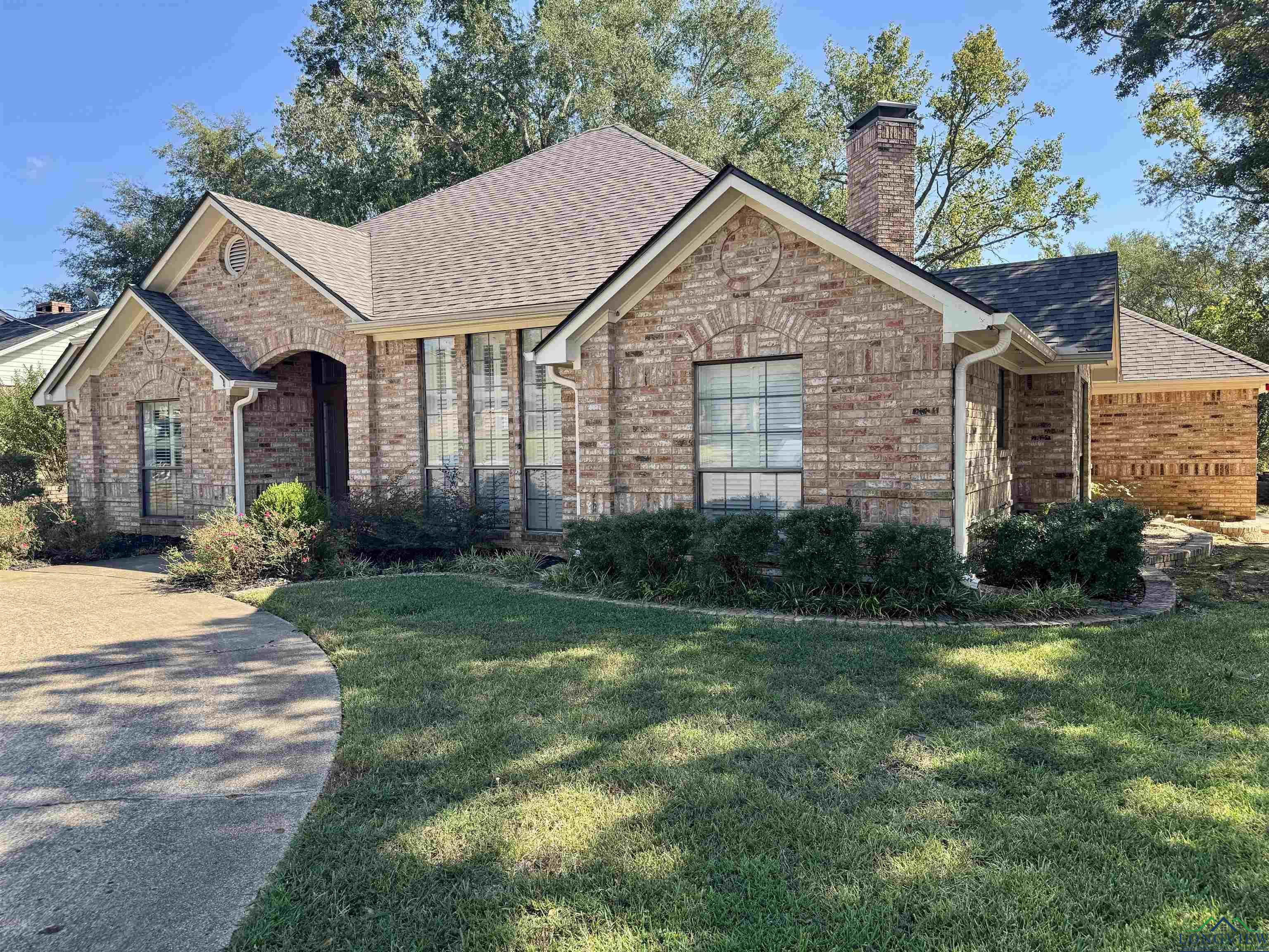 Image 2: Ranch-style house with a front yard, brick siding, and a chimney, Front Of Structure