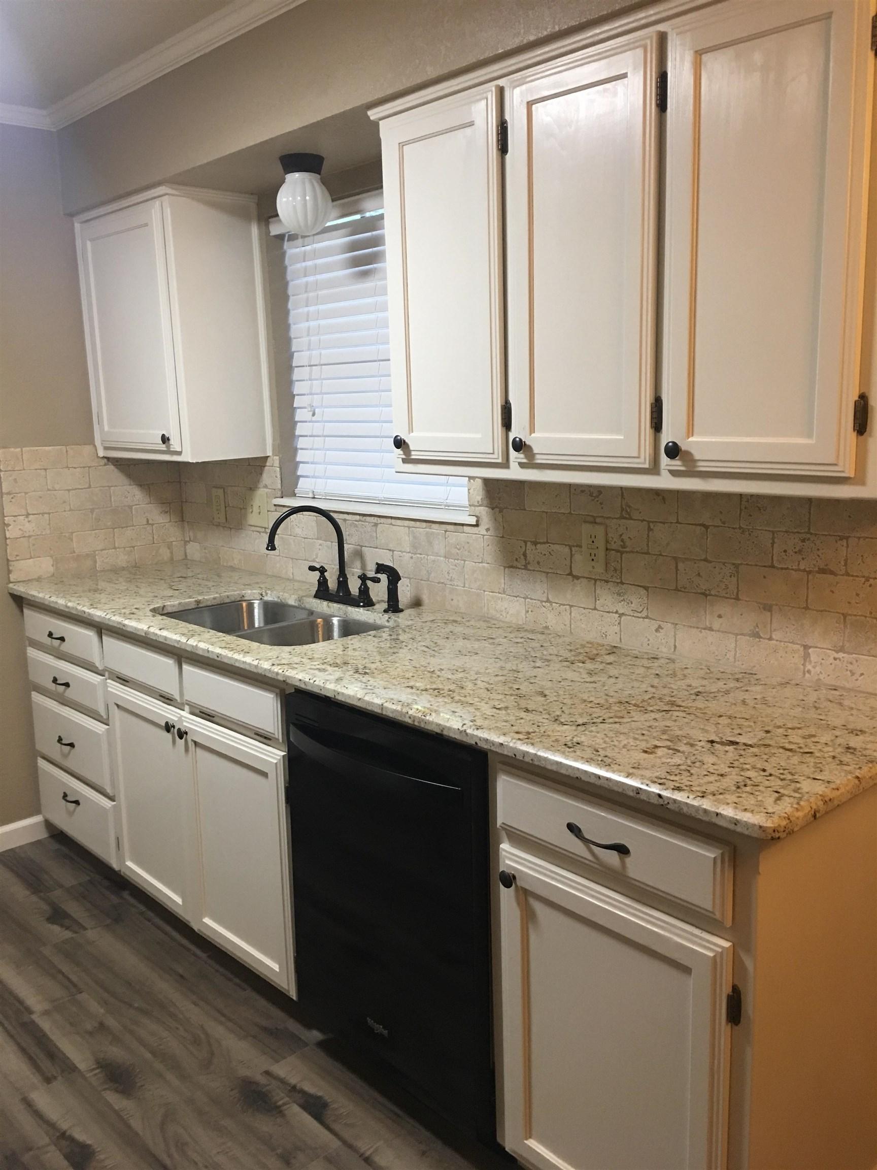 Image 2: Kitchen featuring white cabinetry, light stone countertops, dishwasher, dark wood-type flooring, and ornamental molding, Kitchen