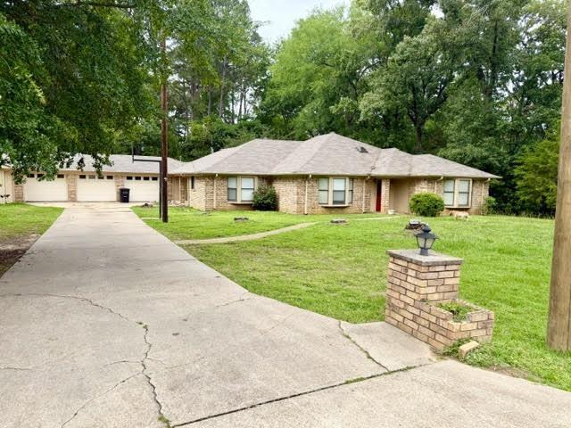 Image 1: Brick facade residence featuring multiple bay windows, a multi-car garage, and a concrete driveway, Front Of Structure