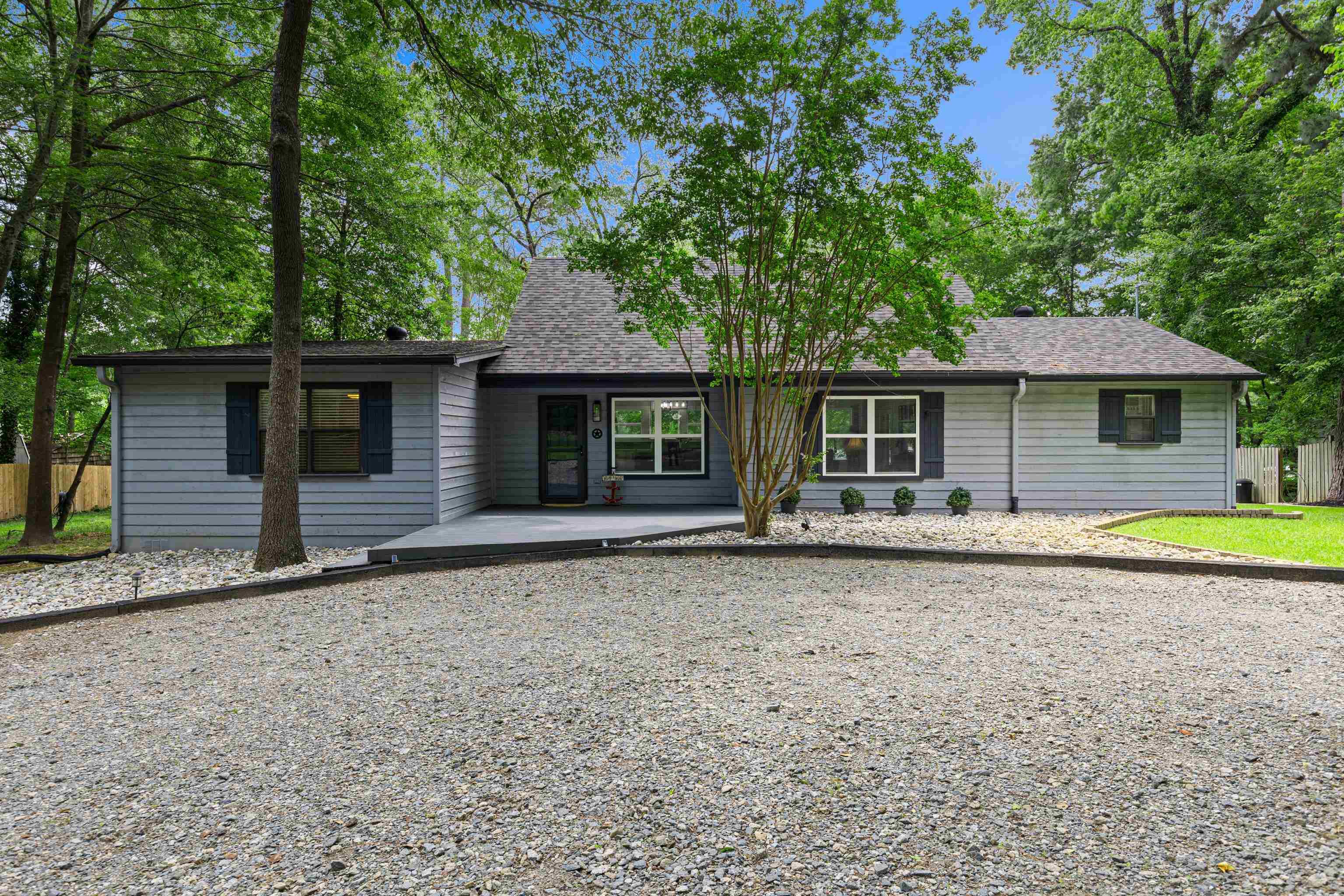 Image 0: Contemporary gray siding residence featuring a dark gray shingle roof and black shutters, Front Of Structure