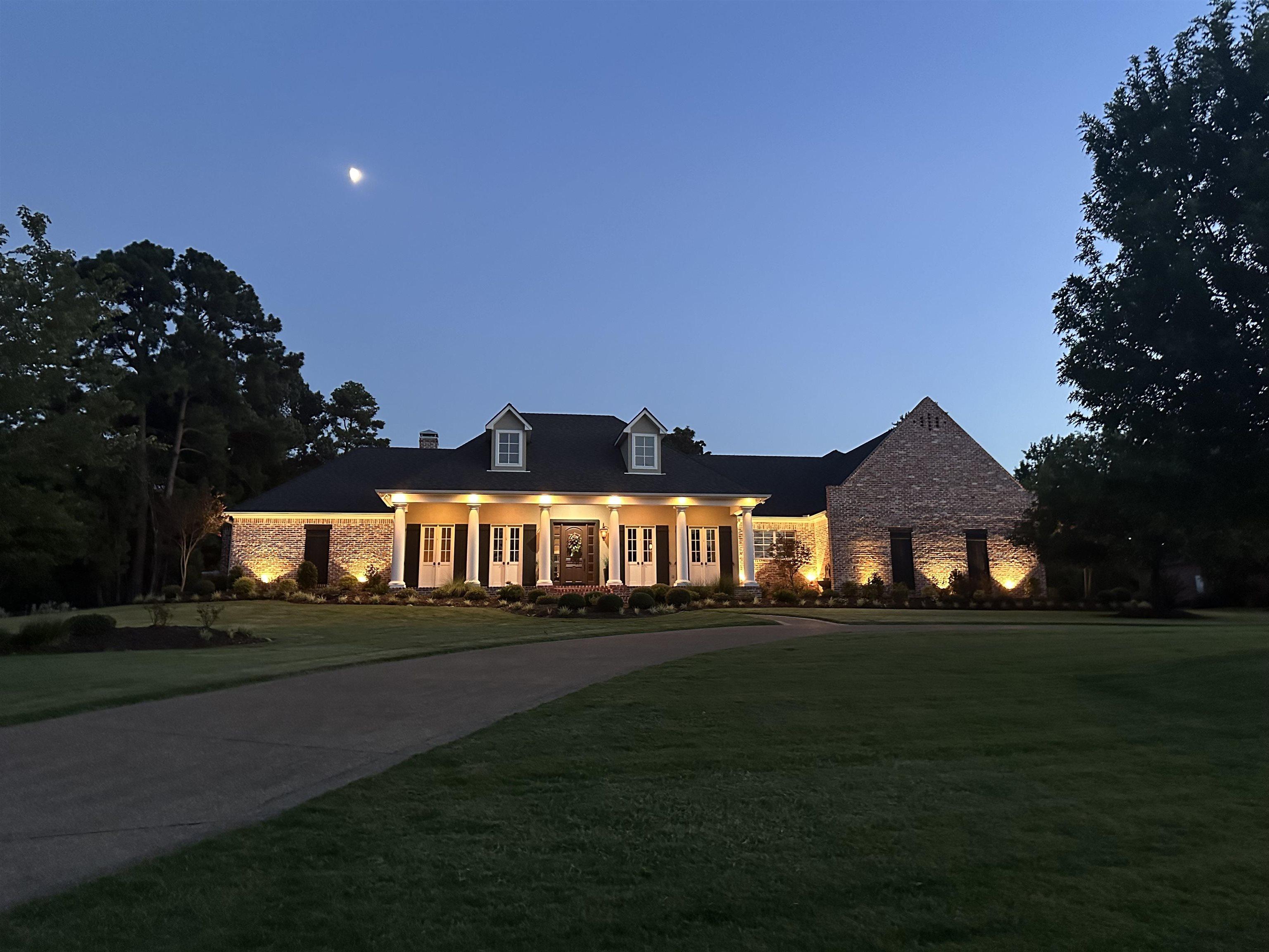 Image 1: Traditional-style residence featuring a brick facade and a prominent columned portico, Front Of Structure