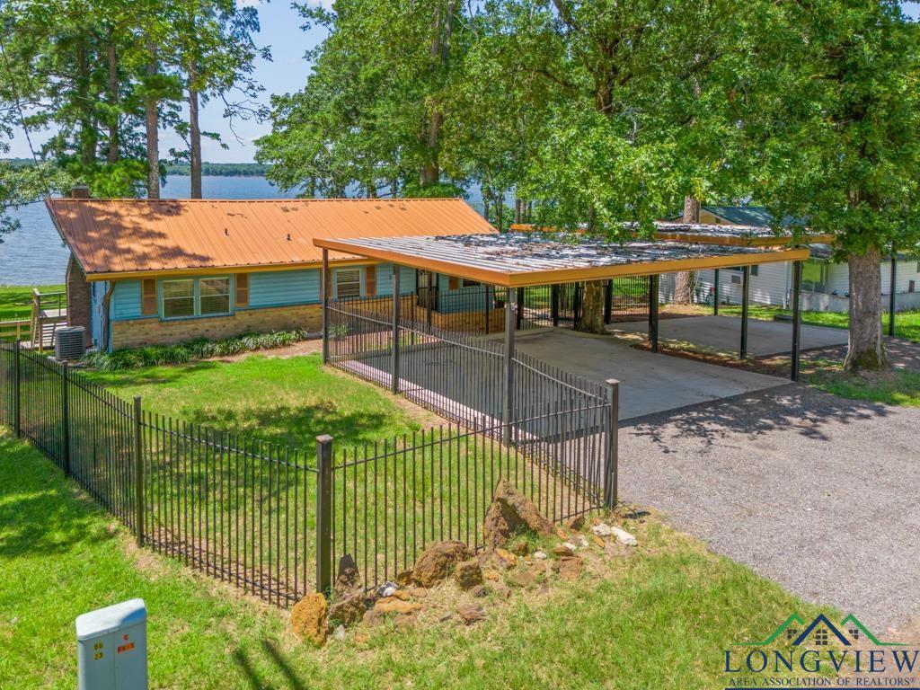 Image 0: View of home's community with driveway, a water view, and a carport, Community