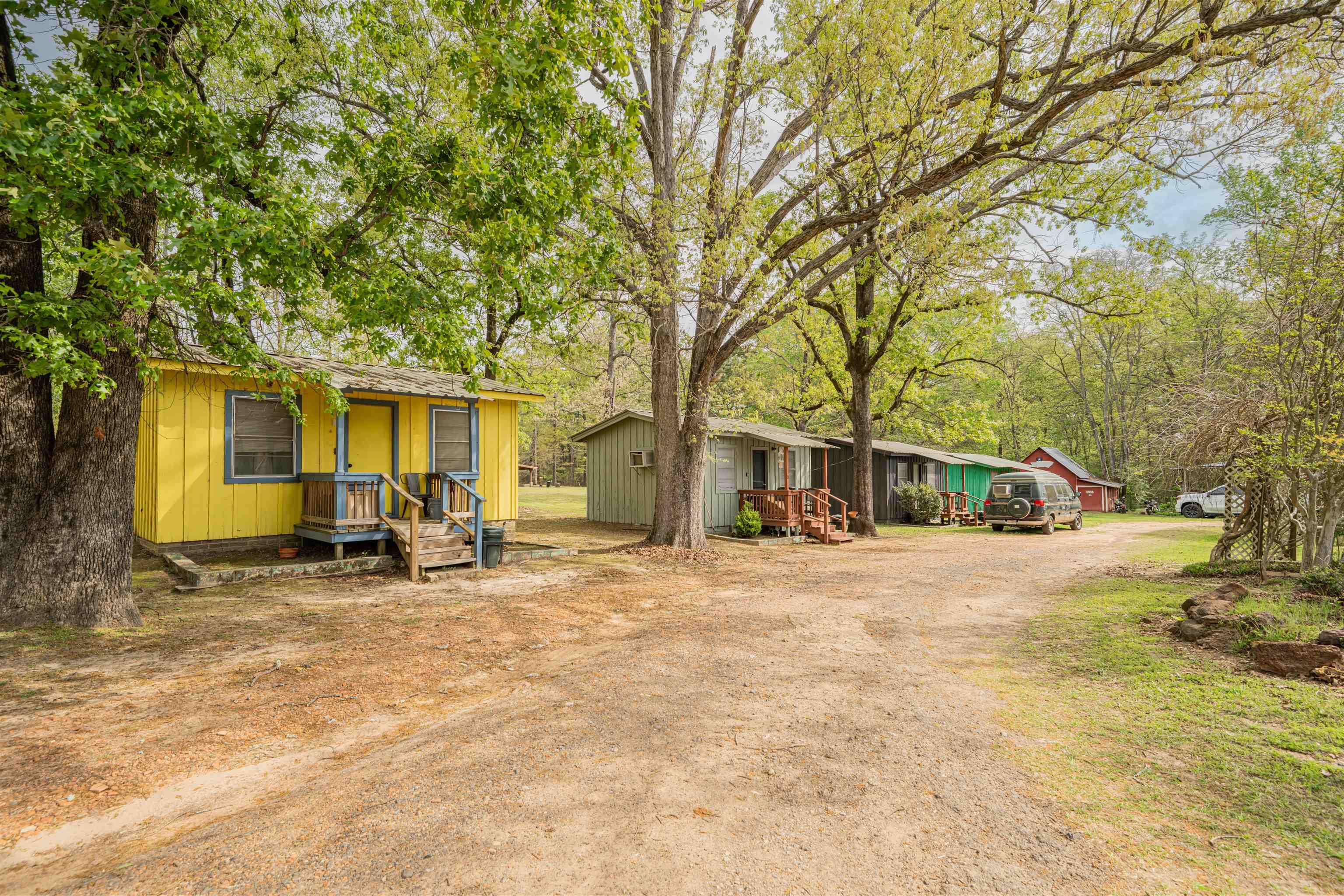 Image 1: Manufactured / mobile home featuring driveway and view of wooded area, Front Of Structure