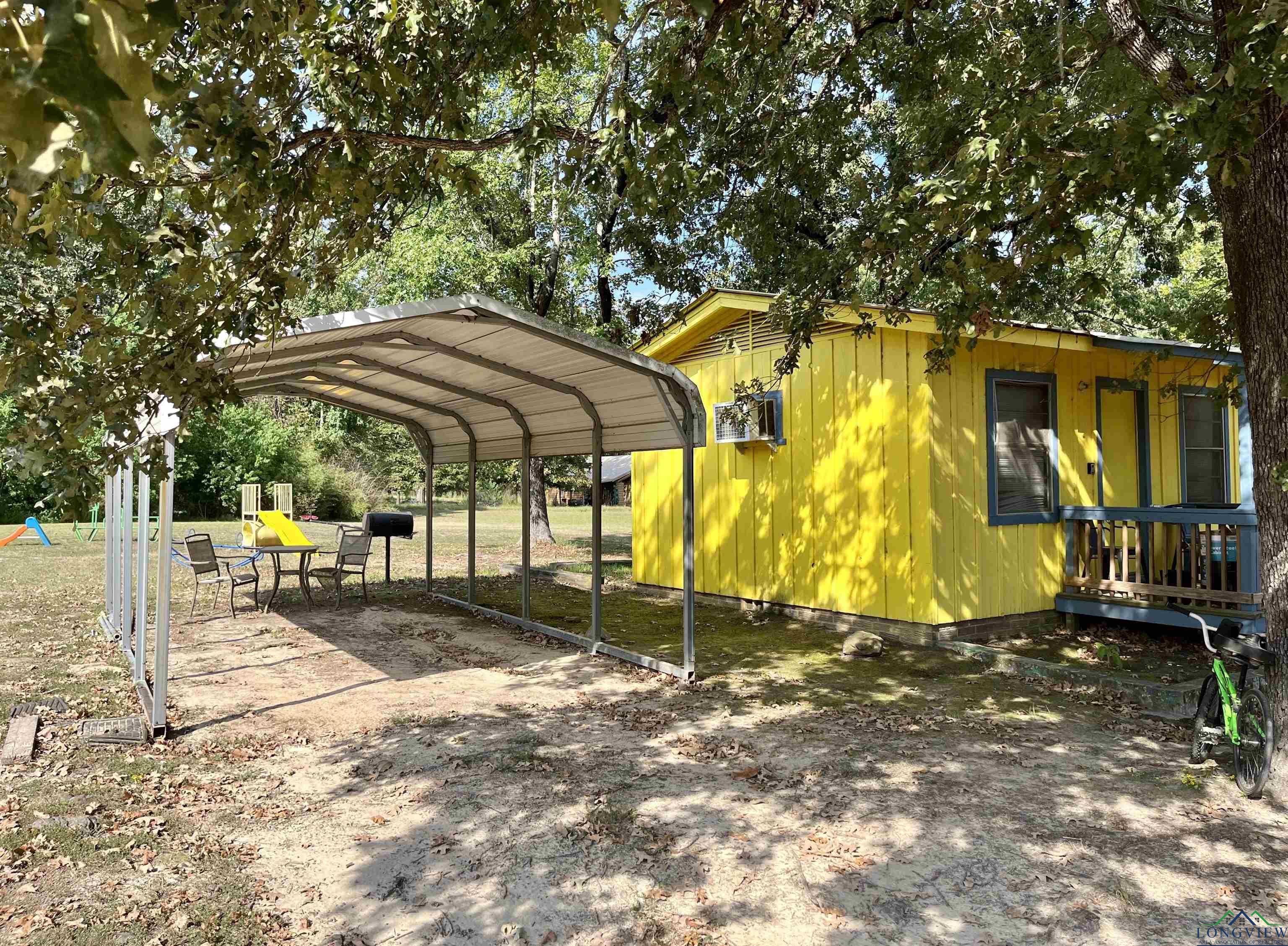 Image 3: View of side of home featuring a detached carport, Cabin #4
