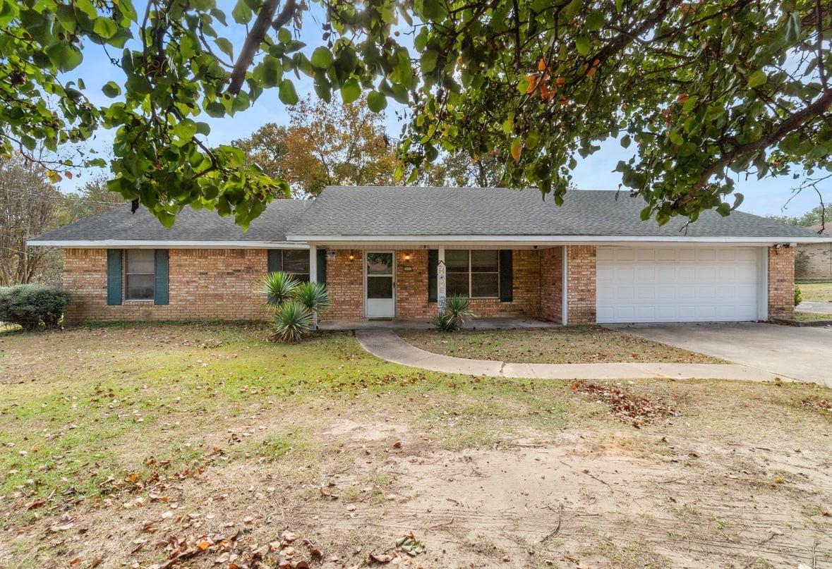 Image 0: Ranch-style home with covered porch, brick siding, concrete driveway, and roof with shingles, Front Of Structure