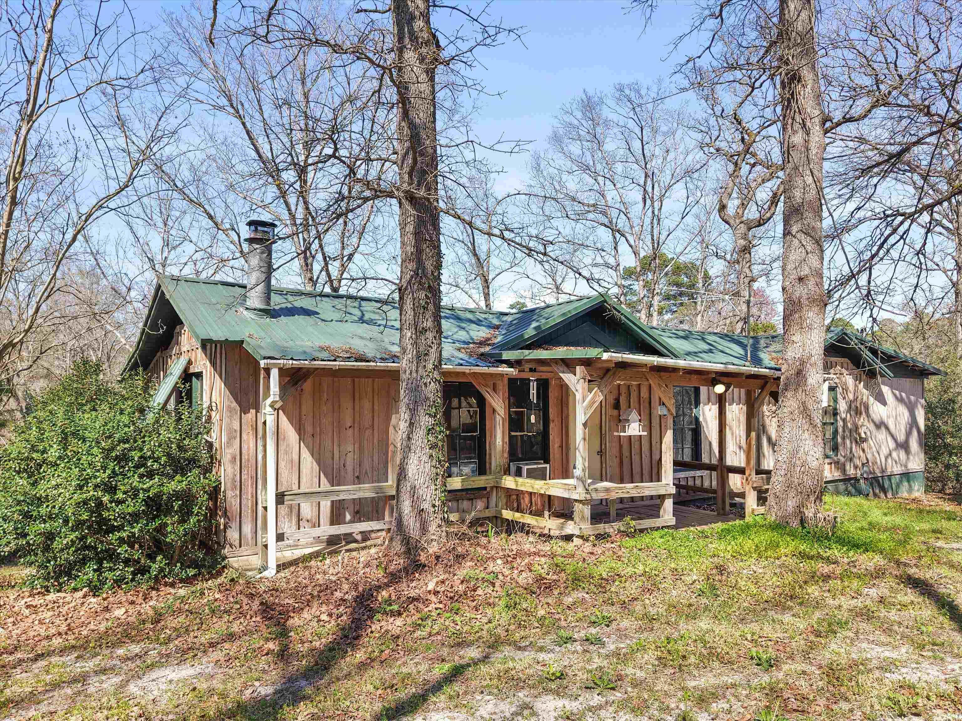 Image 0: View of front of home with a metal roof, board and batten siding, and a porch, Front Of Structure