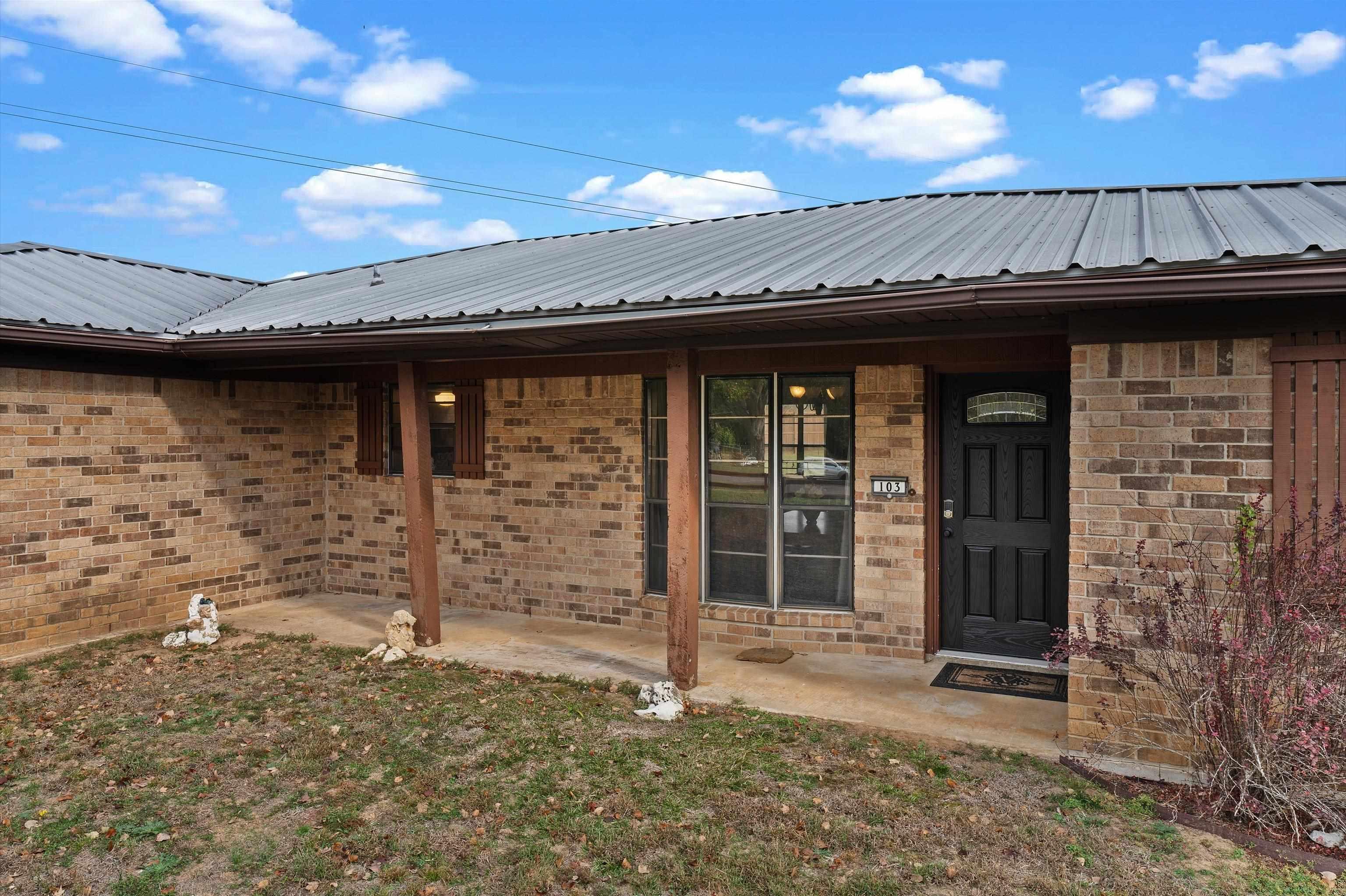Image 3: Property entrance with brick siding and a metal roof, Entry