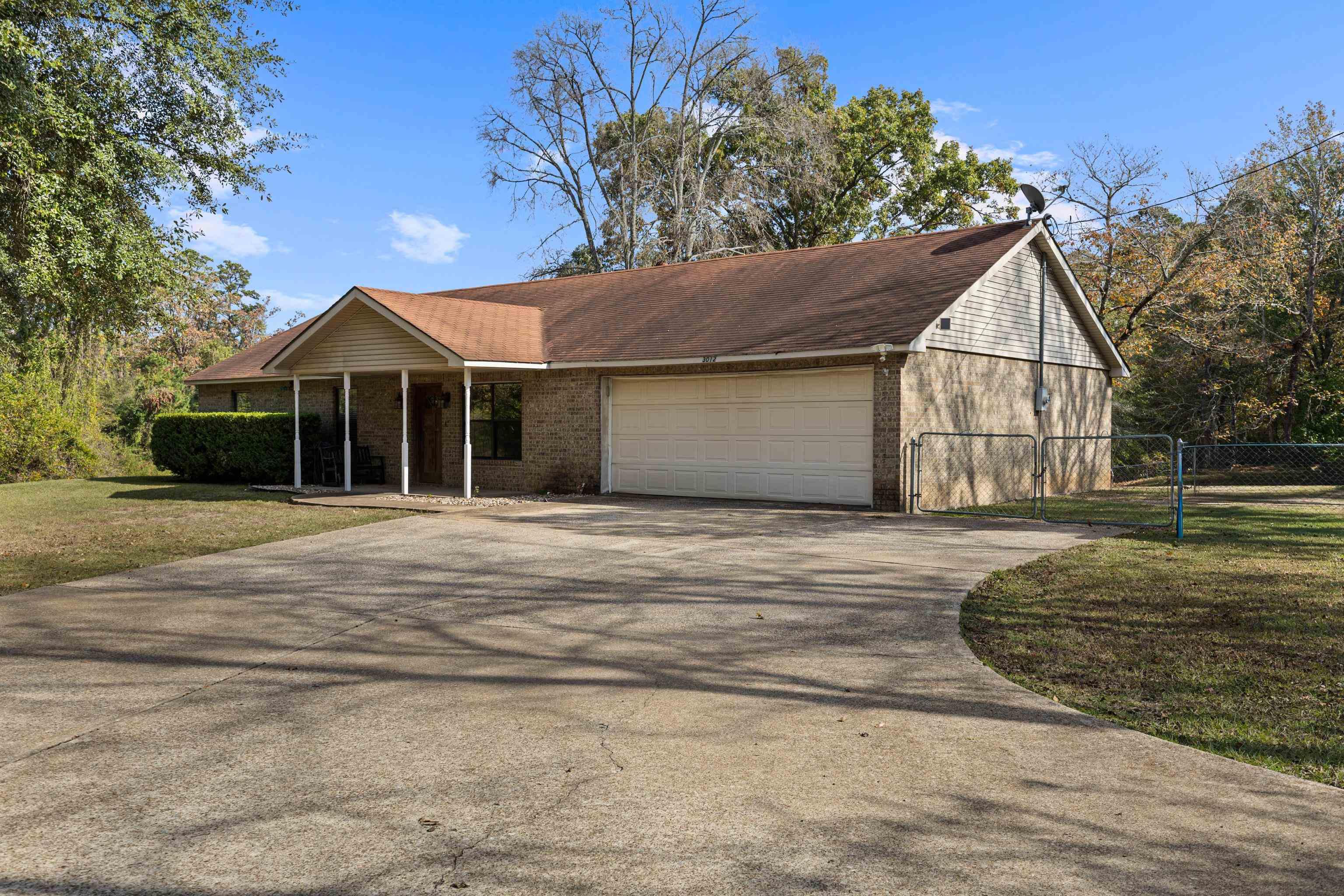 Image 3: Ranch-style home with driveway, a garage, and brick siding, Front Of Structure