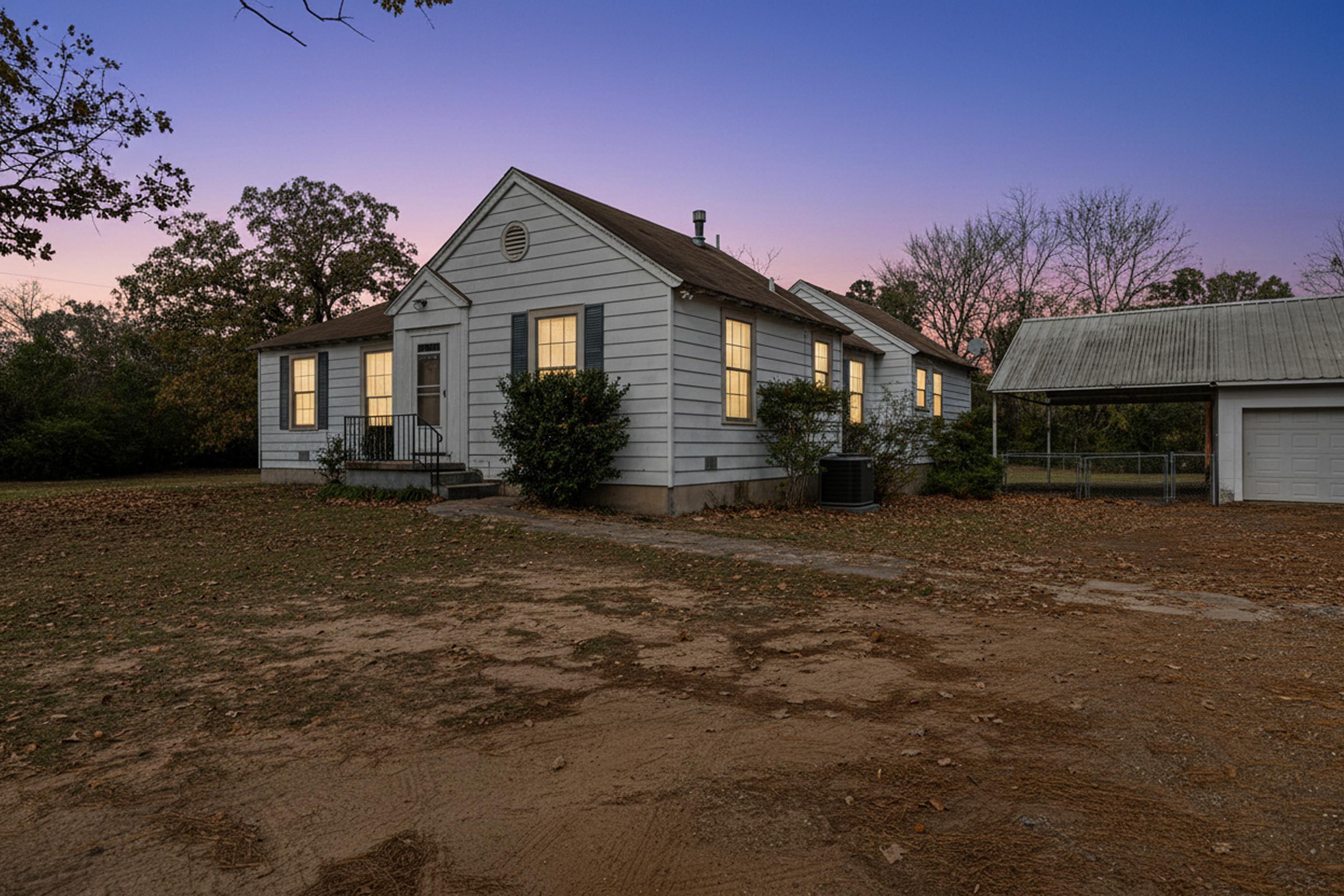 Image 1: View of front of house featuring a carport and a garage, Front Of Structure