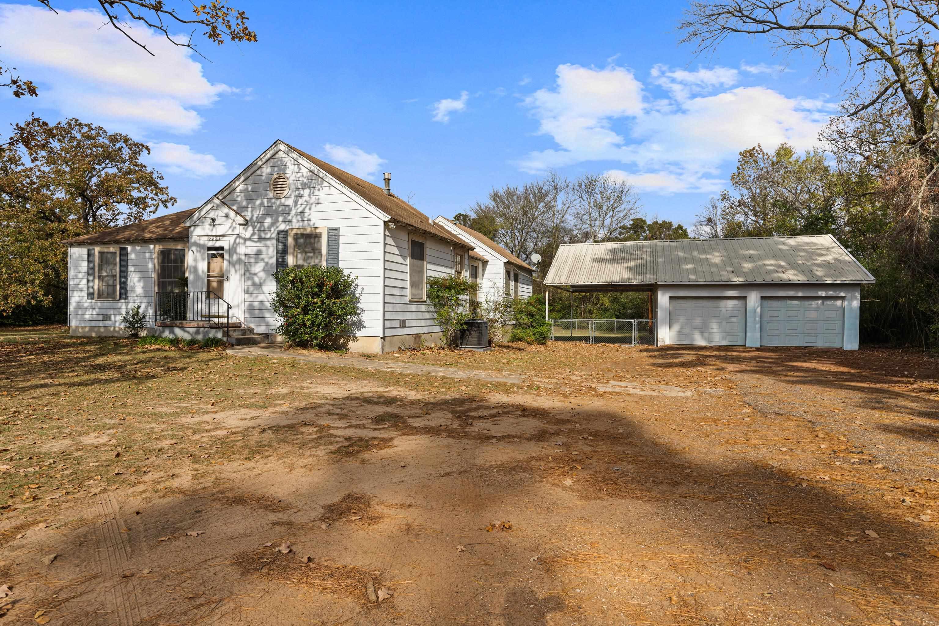 Image 3: View of front of property with an outdoor structure, a carport, and a detached garage, Front Of Structure