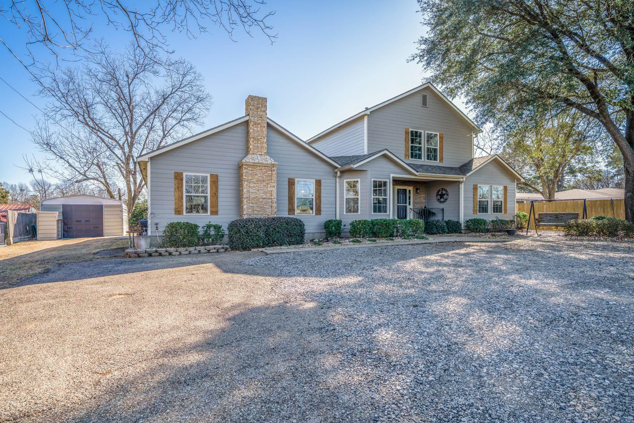 Image 1: View of front of house with a chimney, a porch, and a storage unit, Front Of Structure