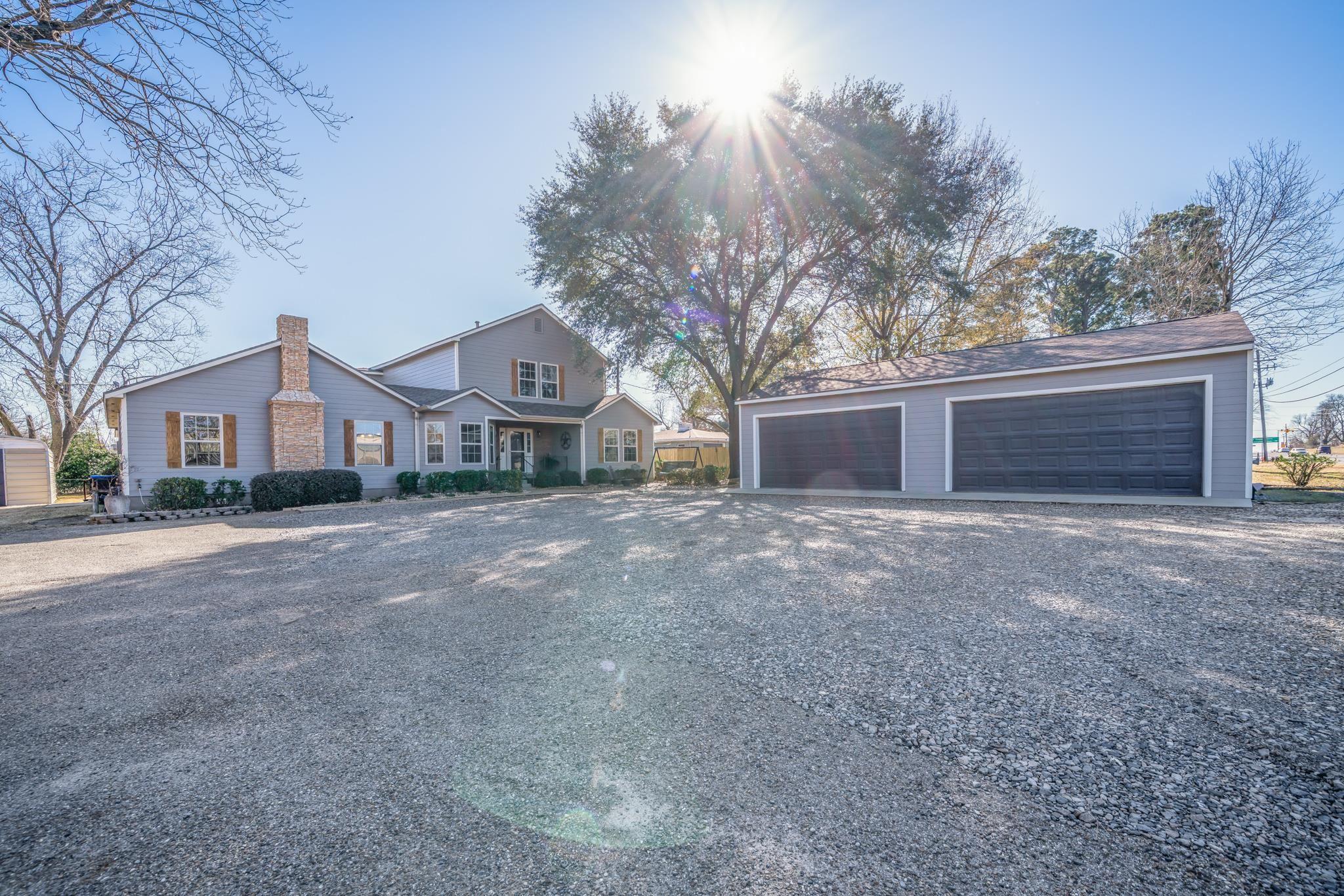 Image 2: View of front of home featuring an outbuilding, a garage, and a chimney, Front Of Structure