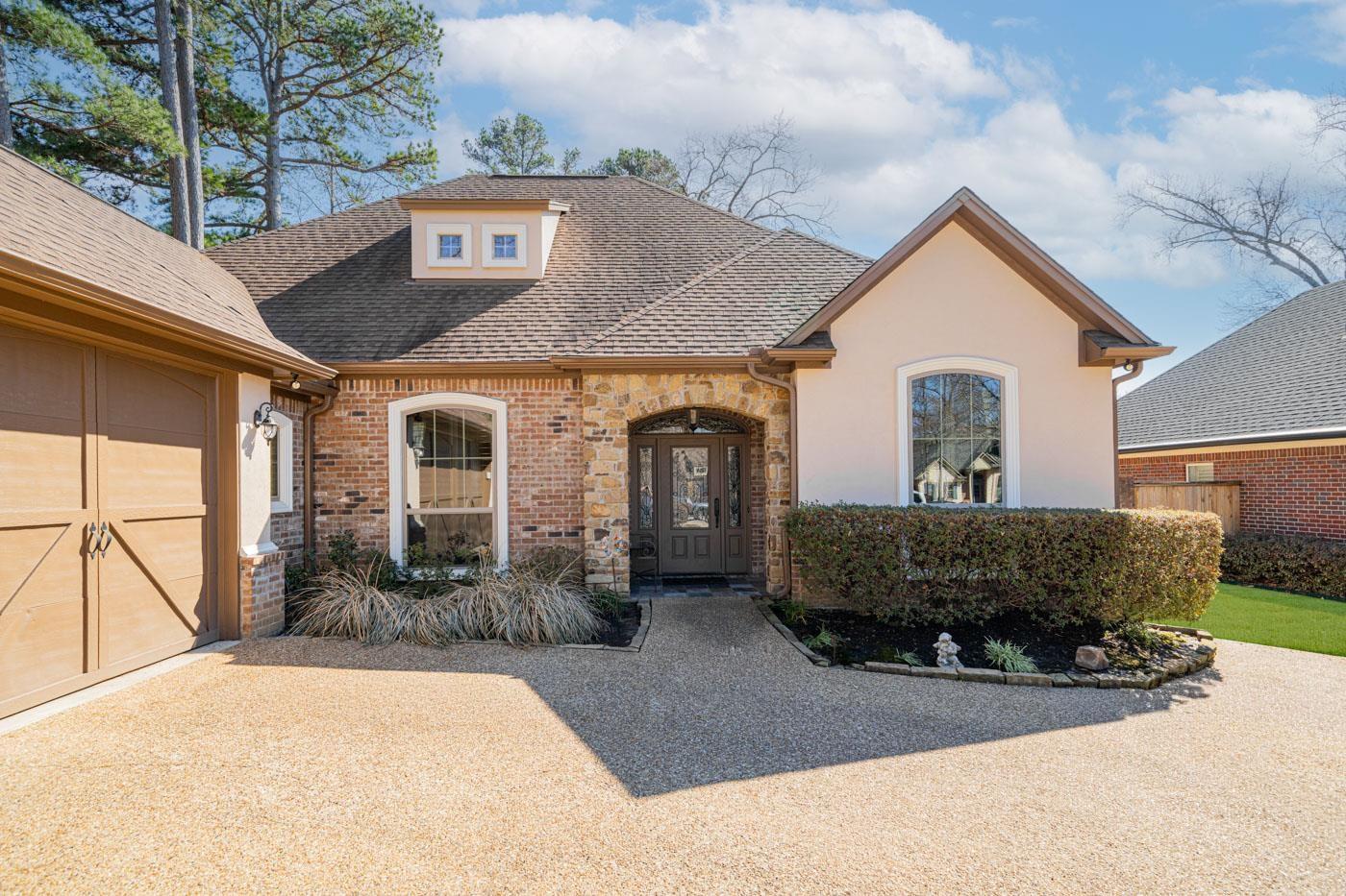 Image 3: View of front of home with a shingled roof, brick siding, stucco siding, and stone siding, Front Of Structure