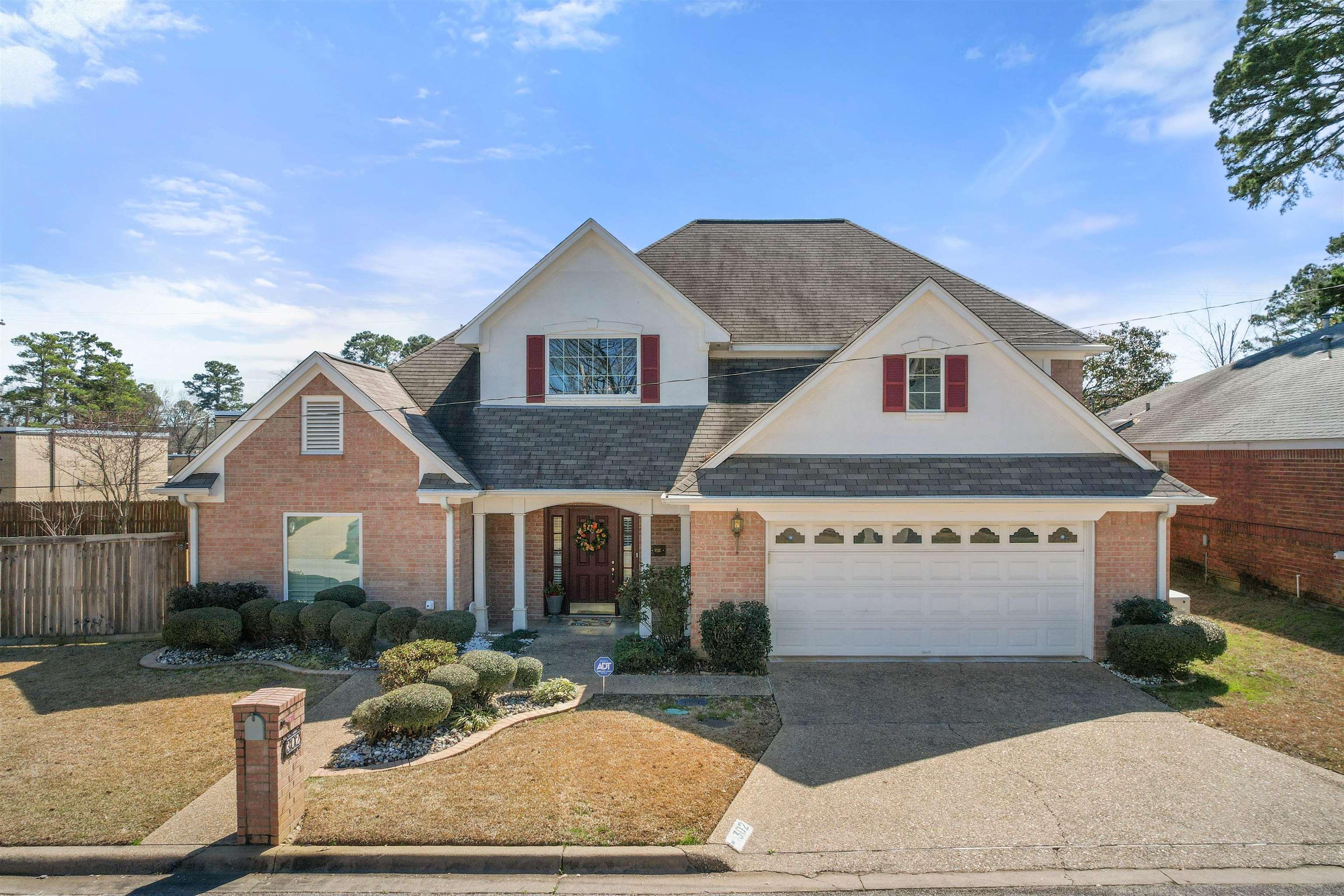 Image 0: Traditional-style home featuring a brick facade with white siding accents and a contrasting dark shingle roof, Front Of Structure