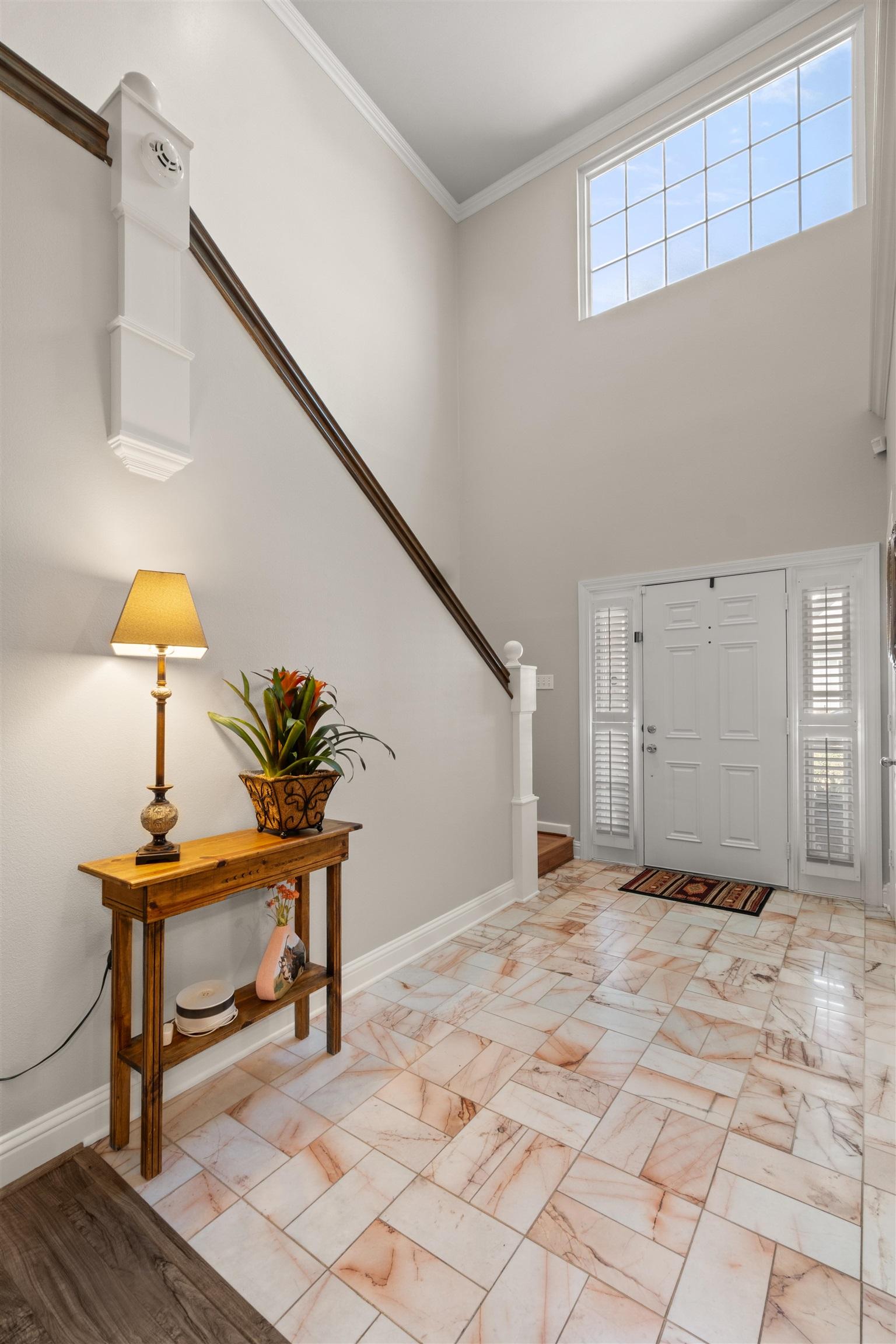 Image 1: Two-story foyer featuring high ceilings and a prominent transom window, Entrance Foyer