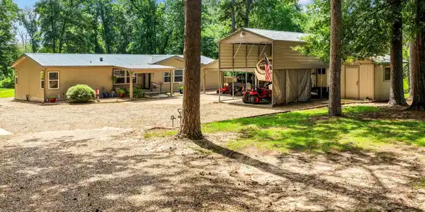Image 2: Ranch-style residence featuring a covered front porch, tan siding, and a metal roof, Back Of Structure