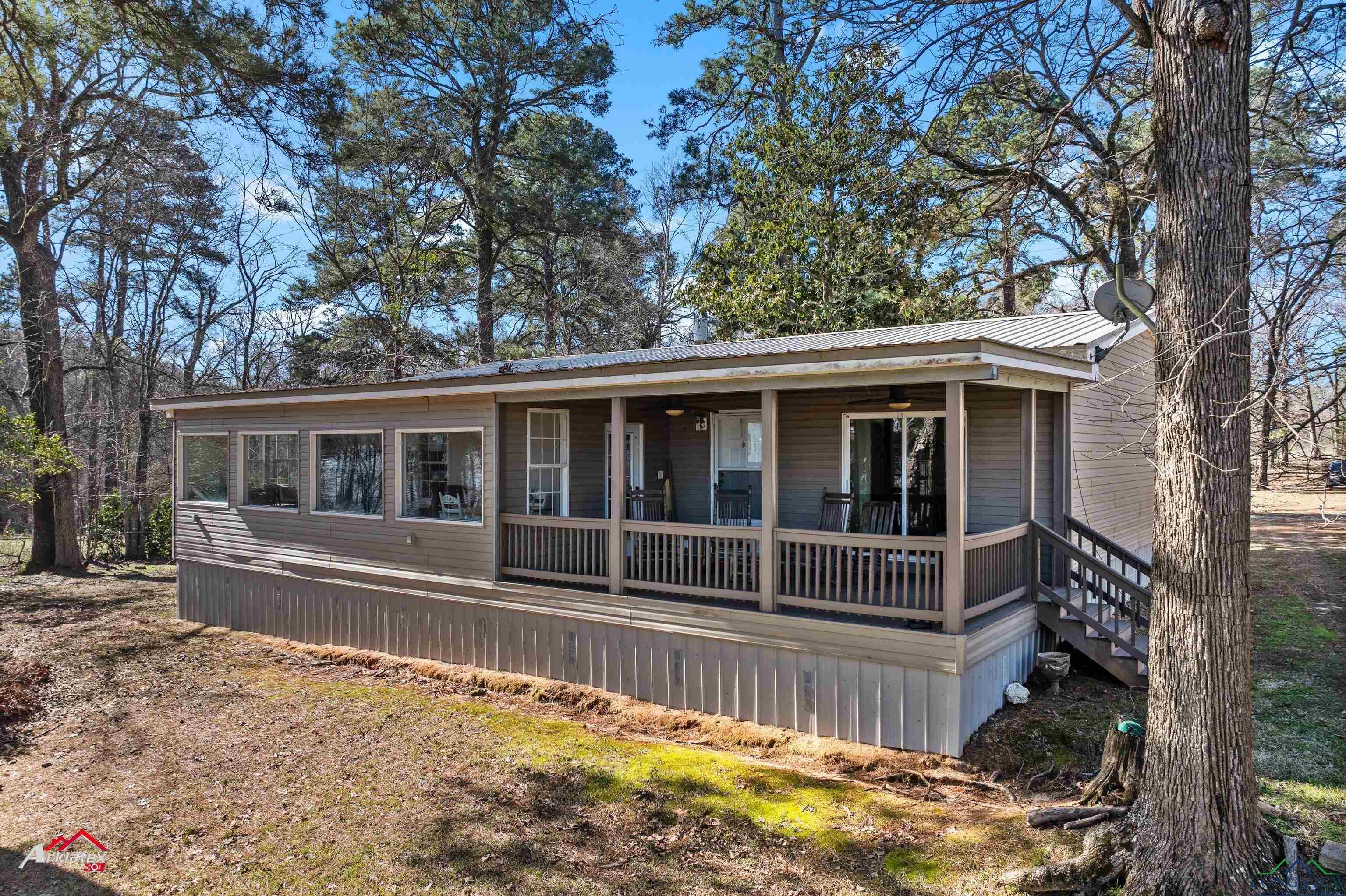 Image 0: Manufactured / mobile home with stairs, metal roof, and a porch, Front Of Structure