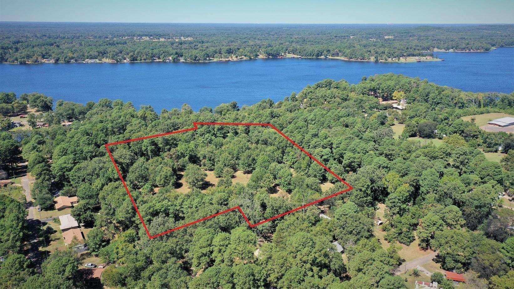 Image 0: Aerial view of property's location featuring a heavily wooded area and property parcel outlined, Aerial View
