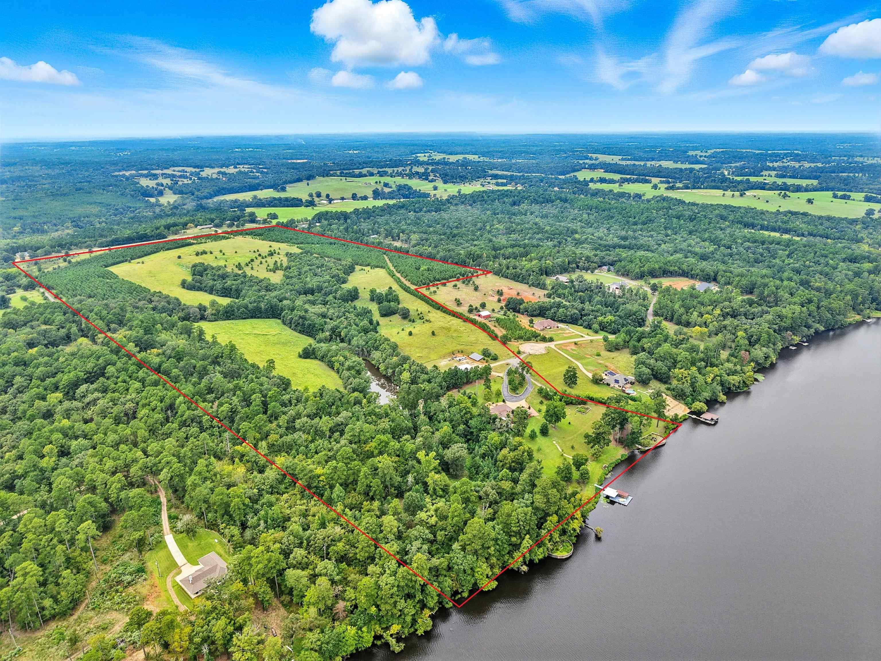 Image 1: Property is gated and fenced. Includes the main house, a guest house, boat house, barn with tractor shed, 1.5 acre pond, trails, oak trees and much more.., lake view