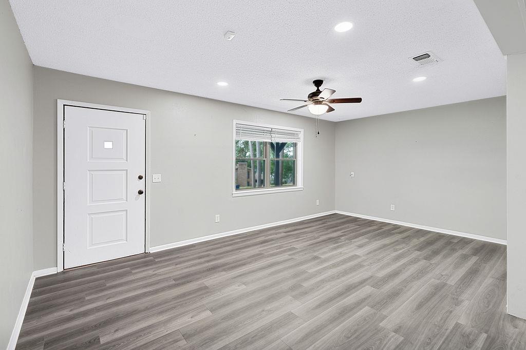 Image 3: Spacious interior featuring wood-finish flooring, recessed lighting, and a ceiling fan, Entrance Foyer