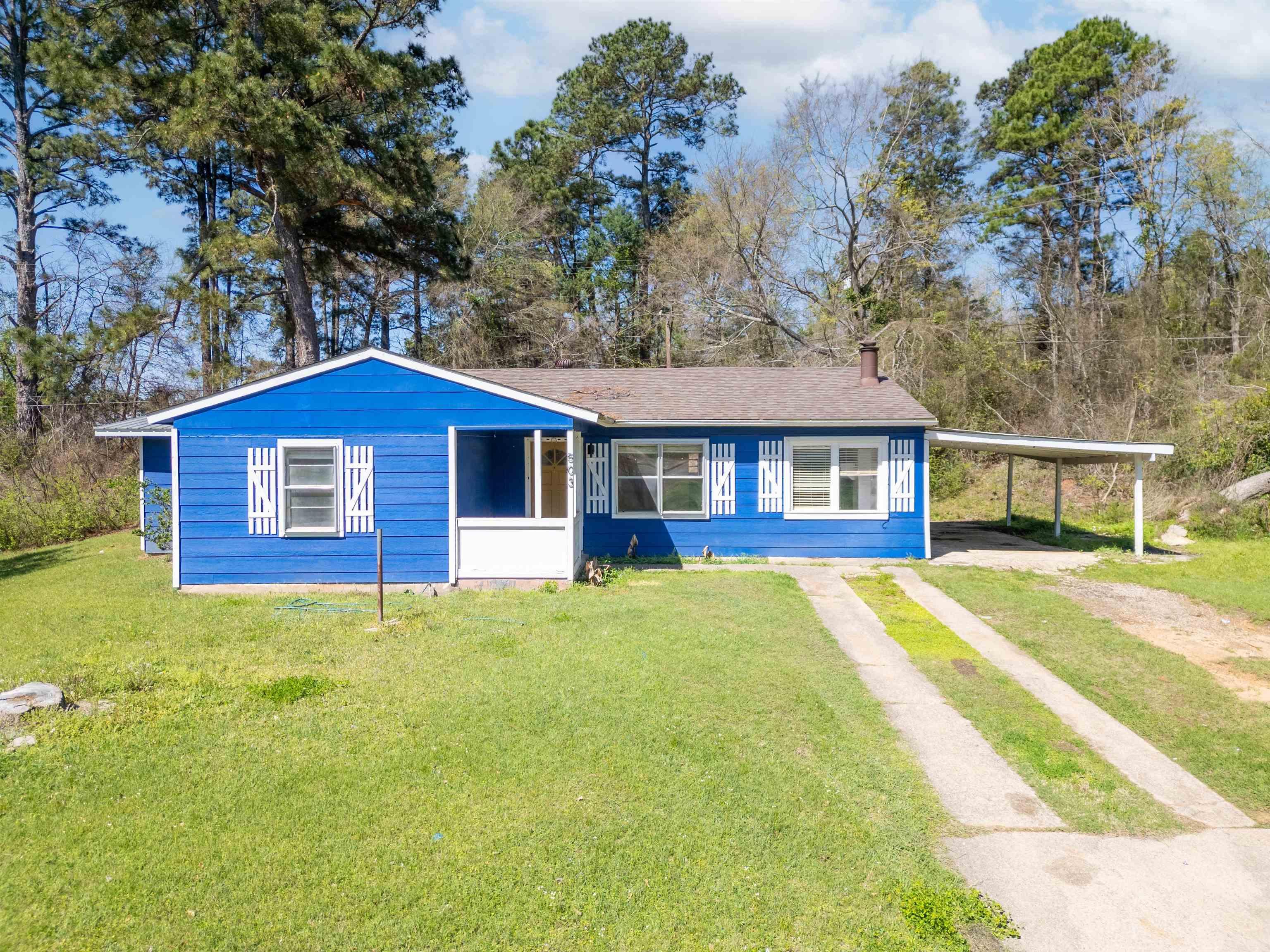 Image 0: View of front of home with a front yard, a carport, driveway, and a chimney, Front Of Structure