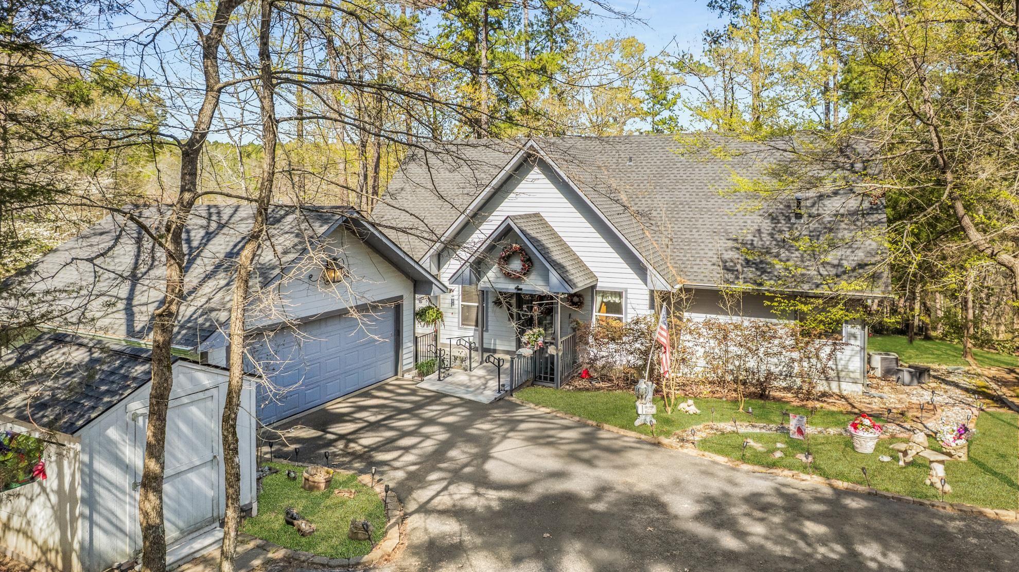 Image 0: View of front of house featuring roof with shingles, driveway, a front lawn, and a storage shed, Front Of Structure