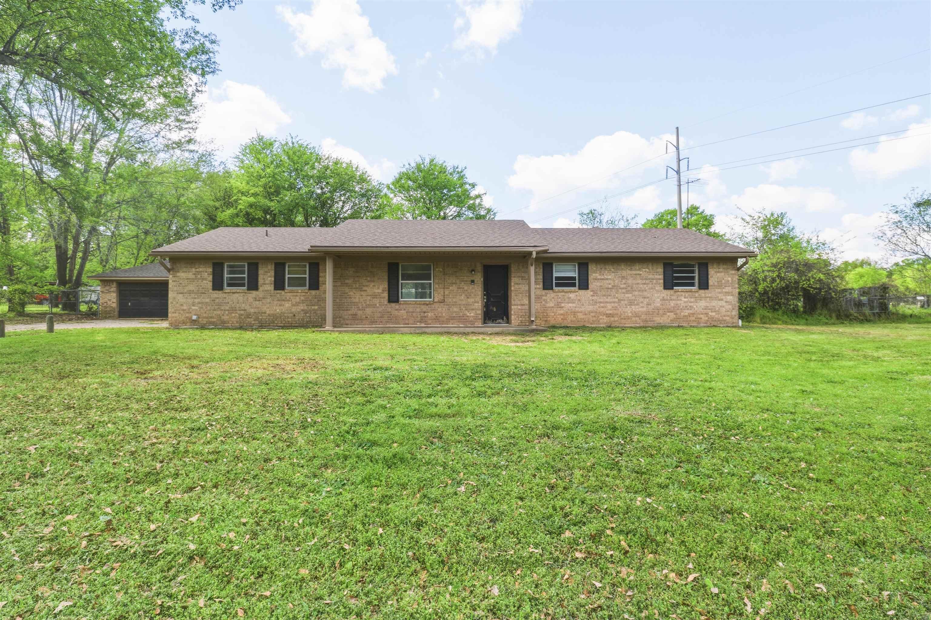 Image 0: Single story home featuring brick siding, a garage, a porch, and roof with shingles, Front Of Structure