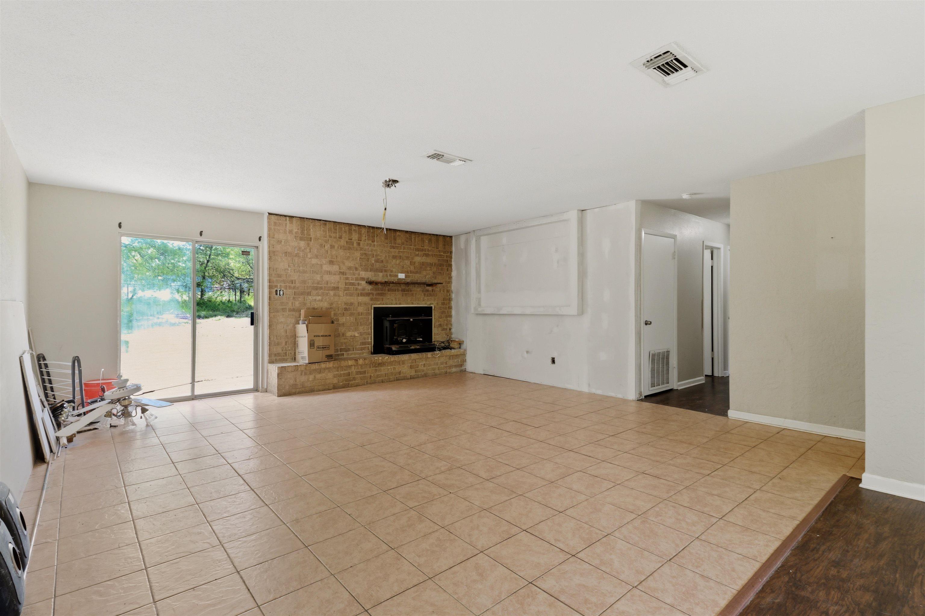 Image 2: Unfurnished living room featuring tile patterned floors and a brick fireplace, Living Room